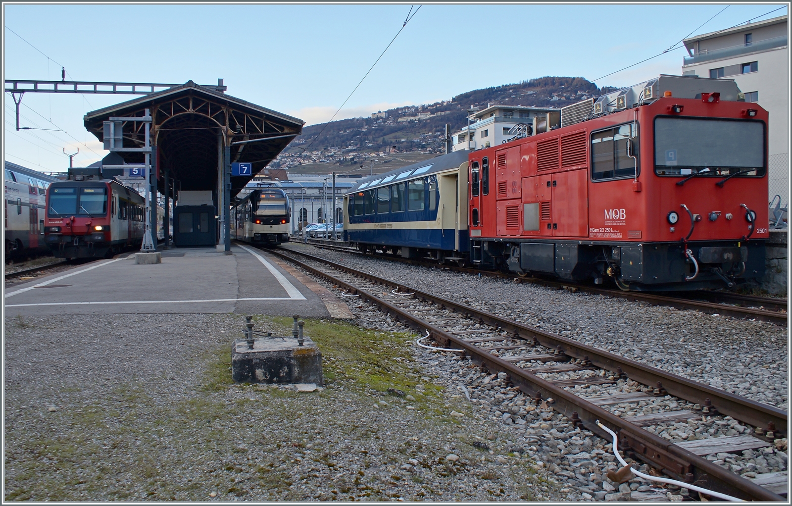 Die MOB HGem 2/2 2501 (ex MVR HGem 2/2 2501) und der vor einigen Jahren zum Jubiläum  40 Jahre GoldenPass Express  vor einigen Jahren in den farblichen Ursprungszustand zurückversetze MOB As 110 zeigen sich in Vevey. Wo der Rest des Tags zuvor in Blonay fotografieren Zuges abgeblieben ist, konnte ich leider nicht feststellen.

In der linken Bildhälfte zeigt sich der CEV ABeh 2/6 nach Blonay und ein SBB Domino nach Chexbres. 
 
4. Februar 2023