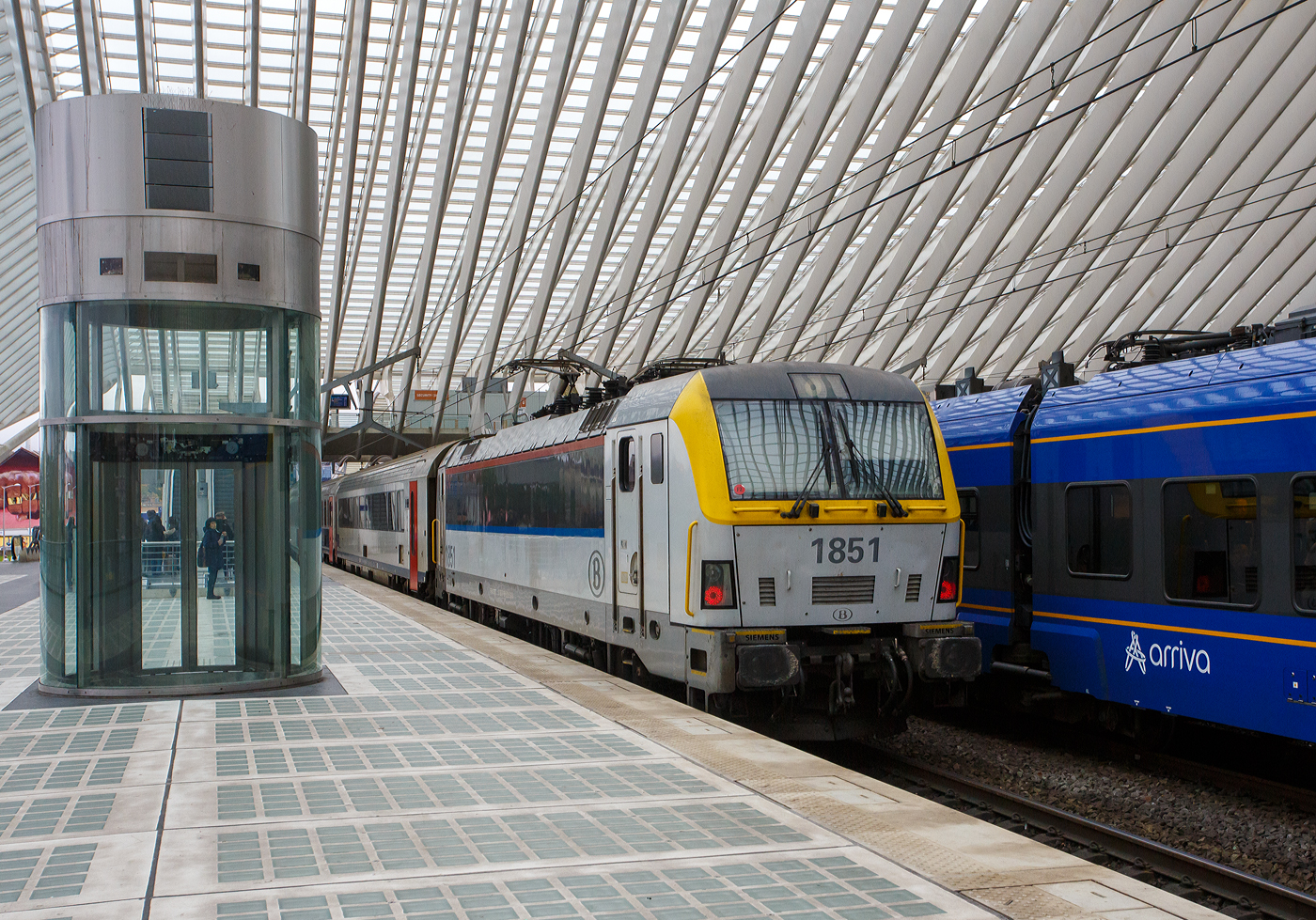 Die NMBS/SNCB HLE 1851 schiebt den IC (Ostende – Brügge – Gent – Brüssel - Lüttich/Liège-Guillemins – Eupen) am 21 Oktober 2025 vom Bahnhof Liège-Guillemins weiter. Diese IC im Sandwich gefahren, so ist an der Zugspitze eine weitere Siemens der Serie/ Reeks 18.