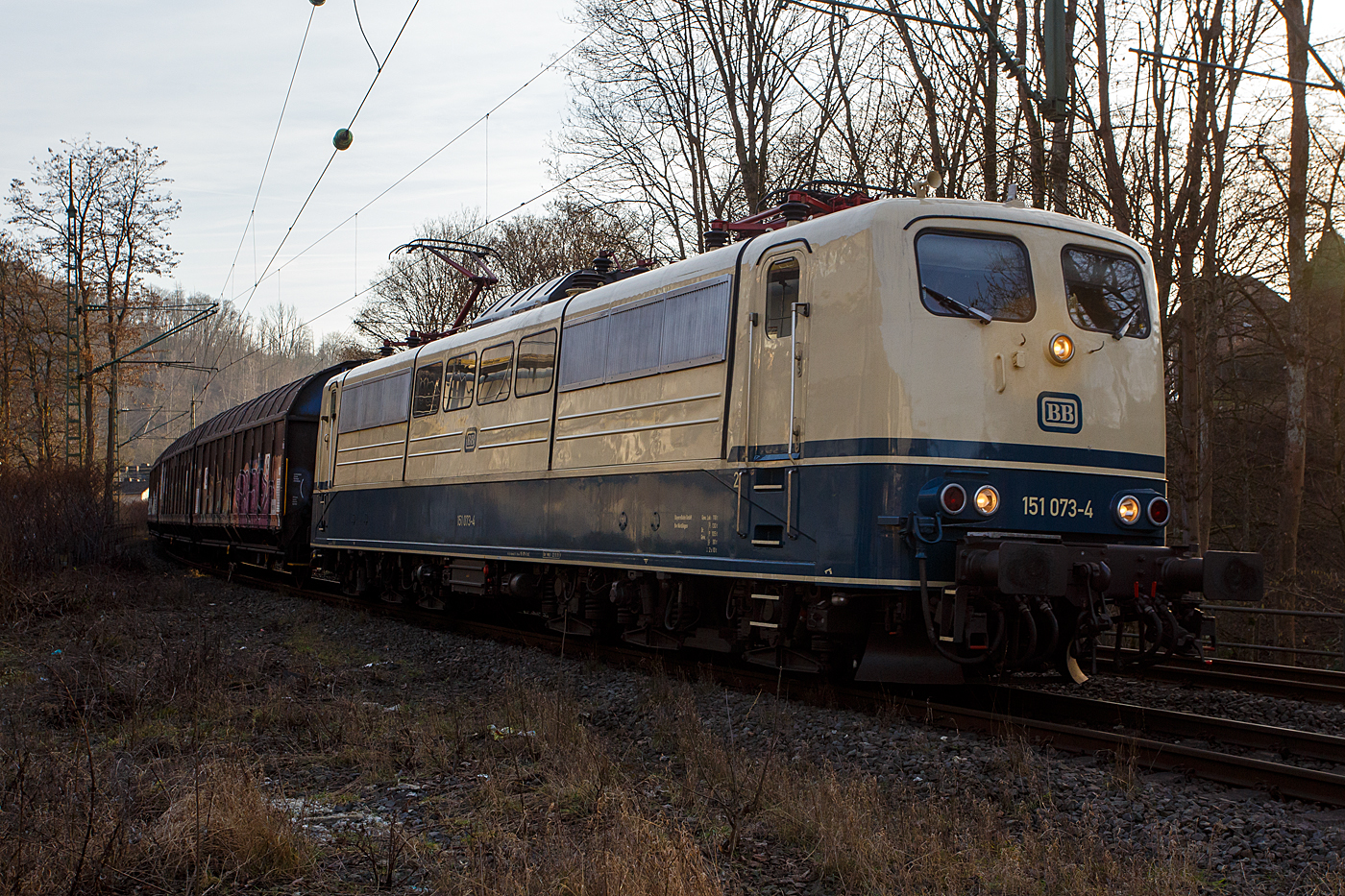 Die ozeanblau/beige BB151 073-4 (91 80 6151 073-4 D-BYB) der BayernBahn GmbH (Nördlingen) fährt am 22 Januar 2026, mit dem  Henkelzug  (Langenfeld/Rhld. nach Gunzenhausen), durch Kirchen/Sieg in Richtung Siegen.

Die 151 073-4 wurde 1974 von Henschel in Kassel unter der Fabriknummer 31816 gebaut und in der Farbgebung ozeanblau/beige an die Deutsche Bundesbahn ausgeliefert. Zum 01.01.2017 wurden je 100 sechsachsige elektrische Altbau-Lokomotiven der Baureihen 151 und 155 an den Lokvermieter Railpool verkauft, so auch diese. 2019 wurde die 151er an die BayernBahn GmbH in Nördlingen verkauft.

Die BayernBahn ist übrigens eine Tochtergesellschaft des Bayerischen Eisenbahnmuseums e.V.. Sie besitzt z.Z. 6 dieser mit 5.982 kW leistungsstarken und bis zu 120 km/h schnellen Maschinen der Baureihe 151. 