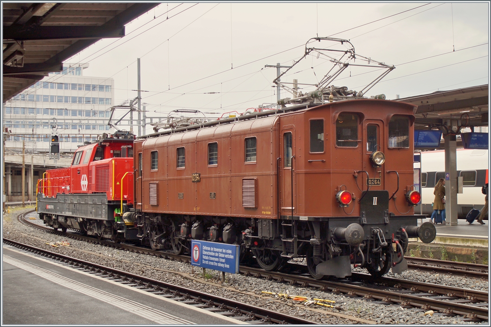 Die SBB Historic Ae 3/6 III 10264 schiebt in Lausanne ein mächtiges ETCS Gerät in Form einer Aem 940 vor sich her. Die Lok ist wohl auf der Rückfahrt vom Dépôt Fest in Olten nach  St-Maurice. Bilder ohne das störende  Überschreiten der Geleise verboten  - Schildes folgen.

28. August 2023