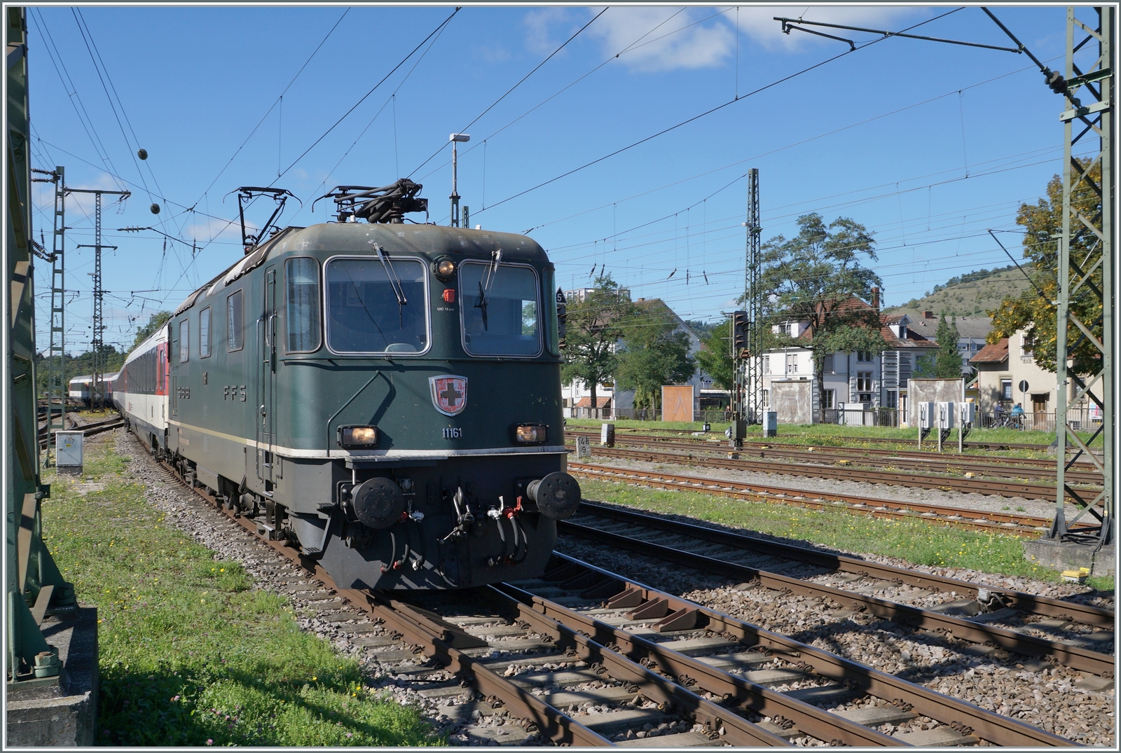 Die SBB Re 4/4 II 11161 in ihrer grünen Lackierung erreicht mit einem IC von Zürich nach Stuttgart den Bahnhof Singen. 

Die grüne Farbe ist übrigens NICHT die Ursprungs-Lackierung der Re 4/4 II 11161, die Lok wurde 1967 in TEE Farben ausgeliefert und bekam erst nach dem Ende des TEE-Einsatzes 1981/82 die heutige grüne Lackierung. 19. September 2022