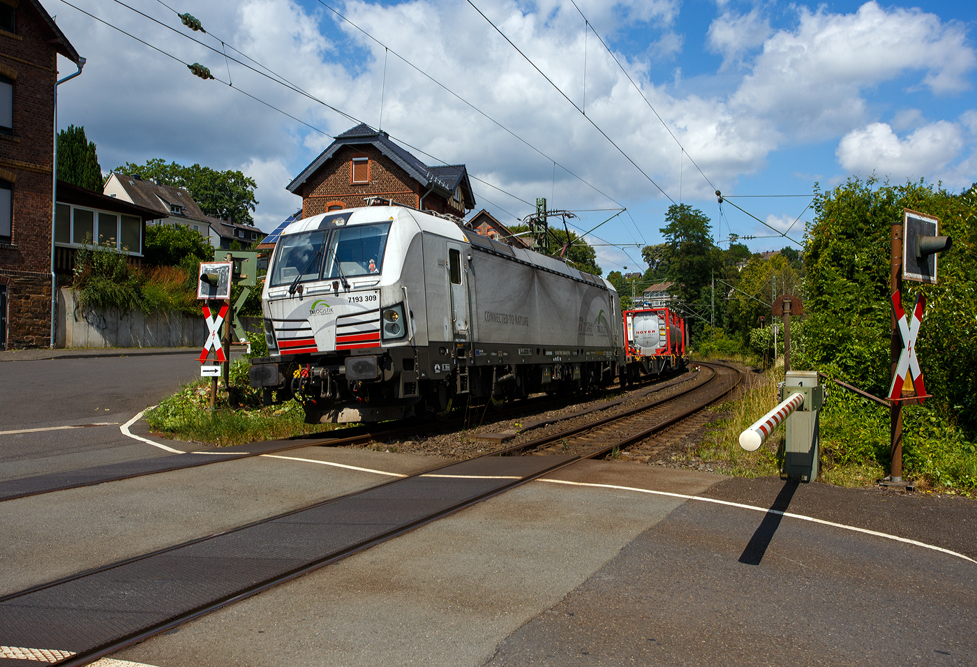 Die TX Logistik AG hat nun auch eigene SIEMENS Vectron, bisher hatte diese nur Loks angemietet. Die recht neue weiße TXL 7193 309 „Connected to Nature“ (91 80 7193 309-0 D-TXL) der TXL - TX Logistik AG (Troisdorf) fährt am 17 Juli 2025, mit einem KLV-Zug, durch Kirchen (Sieg), hier beim Bü km 121,192 in Richtung Betzdorf bzw. Köln.

Nochmals einen lieben Gruß an den netten Lokführer zurück.

Die SIEMENS Vectron MS (X4E) wurde 2024 von Siemens Mobility in München-Allach unter der Fabriknummer 23562 gebaut und am 03.01.2025 an die TXL ausgeliefert. Die mit 6.400 kW konzipierte Mehrsystemlok ist in der Variante A22-11i ausgeführt und hat so die und hat so die Zulassungen und entspr. Länderpakete für Deutschland, Österreich, Schweiz, Italien und die Niederlande (D / A / CH / I / NL).

Über TX Logistik AG
TX Logistik wurde 1999 als privates Eisenbahnverkehrsunternehmen gegründet und bietet mit Verbindungen in elf Ländern ein leistungsfähiges europäisches Netzwerk. Das Unternehmen verfügt über Tochtergesellschaften in der Schweiz, Österreich, Dänemark und Schweden sowie eine lokale Präsenz in Italien. In den Geschäftsbereichen Intermodal und Rail Freight entwickelt TX Logistik umfassende Schienenlösungen für kontinentale und maritime Verkehre sowie maßgeschneiderte Konzepte für konventionelle Fracht. Mit 650 Mitarbeitern und 8,6 Milliarden gefahrenen Tonnenkilometern erwirtschaftete das Unternehmen 2021 einen Jahresumsatz von 253 Millionen Euro. Seit Januar 2017 gehört TX Logistik zu 100 Prozent der Mercitalia Logistics S.p.A., einer Tochtergesellschaft der FS - Ferrovie dello Stato Italiane. Mittlerweile gehört das Unternehmen mit zu den Größten für den Schienengüterverkehr in Europa.

Das Unternehmen bietet den ganzen Umfang an Schienengüterverkehr, inklusive Containertransport und kombiniertem Verkehr an. Wichtigste Transportstrecken sind von den Häfen Hamburg, Bremerhaven, Rotterdam und Antwerpen nach Süddeutschland, Schweiz, Österreich und Italien.

TX Logistik setzt nun auf eigene Vectron Loks:
Anfang Oktober 2024 hat die TX Logistik AG ersten drei von 40 modernen Vectron-Lokomotiven des Herstellers Siemens Mobility aufs Gleis gesetzt, die das zur Mercitalia Logistics (FS Italiane Group) gehörende Schienenlogistikunternehmen im Mai 2023 bestellt hatte. Die Erweiterung der Fahrzeugflotte ist für TX Logistik eine wichtige Voraussetzung, um im intermodalen und grenzüberschreitenden Schienengüterverkehr weiter zu wachsen. Die neuen Lokomotiven werden vor allem auf dem Brenner- und dem Schweiz-Korridor eingesetzt, den strategisch wichtigen Nord-Süd-Achsen in Europa.

Beide Korridore sind stark frequentiert und stellen hohe Anforderungen an die eingesetzten Lokomotiven – von der Zugkraft über die Stabilität bis hin zur grenzüberschreitenden Systemkompatibilität. TX Logistik hat dazu die Maschinen mit verschiedenen Länderpaketen bestellt. 20 Vectron erhalten das Länderpaket für den Betrieb in Deutschland, Österreich, Schweiz, Italien und den Niederlanden (D-A-CH-I-NL) und sollen bis Anfang 2025 übergeben werden. Die Auslieferung der 20 Lokomotiven mit der Ausstattung für den deutsch-österreichisch-italienischen Korridor (D-A-I) soll bis zum Jahresende 2025 erfolgen.

Die Entscheidung für den Kauf der Vectron-Lokomotiven unterstreicht zugleich das Bestreben von TX Logistik, Schienengüterverkehre als umweltfreundliche und effiziente Alternative zum Straßentransport weiter voranzutreiben. Um dies zu unterstreichen und gleichzeitig für den Einstieg in den intermodalen Transport zu werben, hat die erste der drei Vectrons, die im Zughotel in Braunschweig übergeben wurden, eine spezielle Lok-Beklebung mit dem Schriftzug „Start now (Nature). Driven by Green Passion“ erhalten.

Die neuen Loks bieten mit ihrer Flexibilität und Leistungsfähigkeit ideale technische Voraussetzungen, um den steigenden Anforderungen des europäischen Güterverkehrs gerecht zu werden. Mit der modernen Vectron-Flotte, so TX Logistik, sei man mittelfristig nun in der Lage, die Kapazitäten auf dem Brenner- und dem Schweiz-Korridor deutlich zu erhöhen sowie die Effizienz und Zuverlässigkeit im Schienengüterverkehr weiter zu verbessern.
