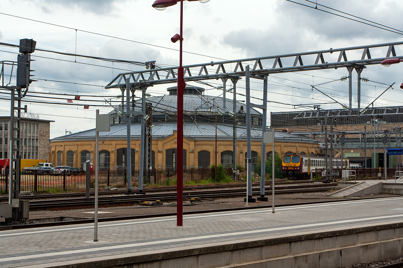 Einer der beiden sogenannten „Rotondes“ nordöstlich des Luxemburger Hauptbahnhofs an der Rue de Bonnevoie am 14 Juni 2013, der Rotondes 1 (der südlichere). Daneben steht der CFL Z2 ein elektrischer Triebwagen der CFL Série 2000, der CFL 2004.

Bei den Rotondes“ handelt es sich um zwei ehemalige Lokschuppen. Die beiden kreisförmigen Gebäude haben einen Durchmesser von jeweils 52 Meter. Ihre Form mit überdachter Drehscheibe ist bei Lokschuppen eher selten anzutreffen, sonst sind eher die Drehscheibe außen vor den Lokschuppen. Die klassizistische Formensprache, die eiserne Tragekonstruktion und die großen Glasflächen sind typisch für ihre Entstehungszeit. Sie wurden 1875 als Lokschuppen (Unterstand und Werkstatt) für Dampflokomotiven errichtet. Nach der Einstellung des Dampfbetriebes nach dem Zweiten Weltkrieg wurden die Rotunde 1 als Lagerhalle und die Rotunde 2 als Reparaturwerkstatt für die Busse der Société Nationale des Chemins de Fer Luxembourgeois (CFL) genutzt. 1985 wurden die beiden Gebäude unter Denkmalschutz gestellt.

Im Jahr 2000 hat das Großherzogtum Luxemburg die unter Denkmalschutz stehenden Gebäude erworben. Ab dem Jahr 2001 erfolgten an der Rotunde 1 umfangreiche Sanierungsarbeiten, während die Rotunde 2 bis zum Jahr 2006 weiter als Busreparaturwerkstatt genutzt wurde. Im Jahr 2007 war Luxemburg „Europäische Kulturhauptstadt“. Rotunde 1 war damals Standort für die Eröffnungsfeier. Im Rahmen des Kulturhauptstadtjahres wurden in den beiden Rotunden zahlreiche Veranstaltungen durchgeführt. Aufgrund des großen Erfolges wurde beschlossen, die Lokschuppen auch weiterhin kulturell zu nutzen. 

Heute sind die beiden Rotunden ein außergewöhnlicher Kultur- und Veranstaltungsort, der stetig weiterentwickelt wird. Die beiden ehemaligen Lokschuppen bieten Raum für kulturelle Veranstaltungen in den Bereichen der darstellenden und der bildenden Kunst sowie der Musik. 