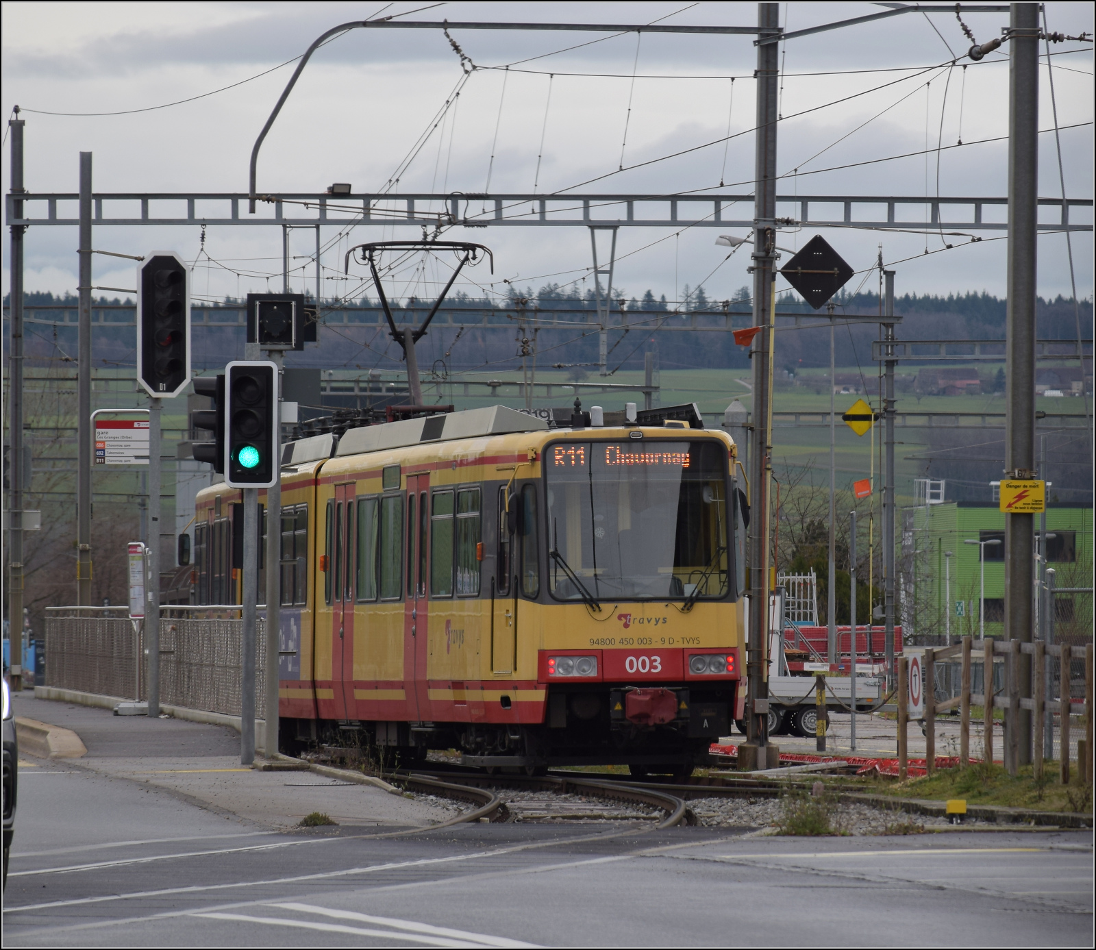 Ende einer �ra - der Gleichstrom und die  Lokalbahn  gehen. 

Die Karlsruher Zweisystem-Strassenbahn  Be 4/8 003  alias 94 800 450 003-9 D-TVYS ist auf dem Weg nach Chavornay bereits inmitten des g��eren Industriegebiets der Kleinstadt Orbe. Dort geht es durch die grossen Gleisanlagen. Dezember 2025.