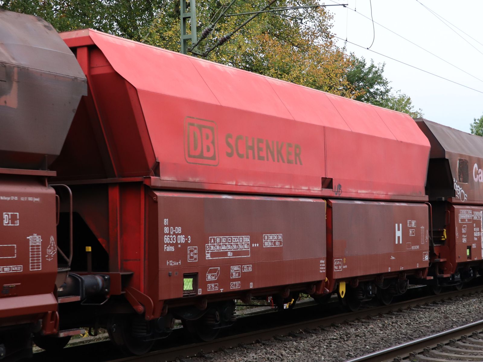 Falns Schttgutwagen mit schlagartiger Schwerkraftentladung mit Nummer 81 80 D-DB 6633 016-3 bei Bahnbergang Grenzweg, Hamminkeln, Deutschland 03-11-2022.

Falns vierassige zelflosser met nummer 81 80 D-DB 6633 016-3 bij de overweg Grenzweg, Hamminkeln, Duitsland 03-11-2022.