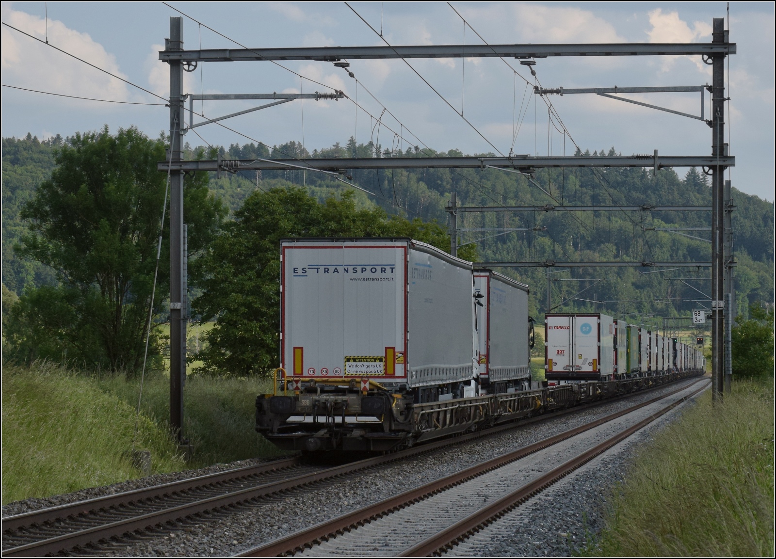 Fernverkehrstag auf der Altstrecke.

Via Burgdorf gibt es zumeist nur noch Güterverkehr, Nahverkehr und überregionale Züge nach Bern. Eine Rola tauchte noch auf mit Re 486 501. Interessant auch die Aufschrift am letzten Sattelzug:  We don't go to UK . Das unrühmliche Thema wird uns wohl so schnell nicht wieder verlassen. Bettenhausen, Juni 2023.