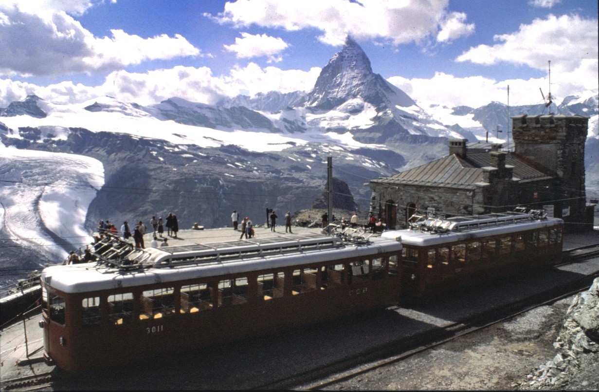 GGB Fahrzeuge Bhe 2/4 Nr.3011 und ein weiterer Triebzug in der Bergstation der Gornergratbahn am 22.08.1979. Im Hintergrund ist ein freier relativ seltener Blick auf das Matterhorn, welches meist in Wolken gehüllt ist.