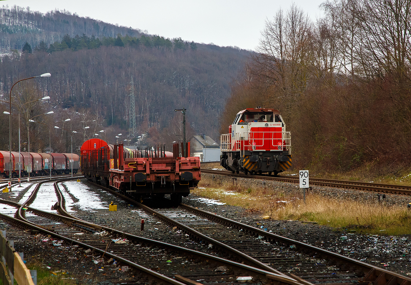 Güterverkehr gibt es noch in Herdorf....
Die KSW 47 (92 80 1271 027-5 D-KSW), ex D 2 der HFM, eine Vossloh G 1000 BB der KSW (Kreisbahn Siegen-Wittgenstein), fährt am 24.01.2023 von Herdorf auf der Hellertalbahn (KBS 462 / Strecke-Nr. 2651) in Richtung Haiger los.

Normalerweise würde sie in Richtung Betzdorf fahren, aber der Streckenanschnitt Herdorf – Betzdorf ist bis min. Ende April gesperrt, so muss die KSW den Umweg über Haiger fahren. Wobei hier als Lokzug ist es nur der Umweg und der entsprechende Mehrverbrauch an Kraftstoff, aber für den Güterverkehr ist noch die Streckenklasse sehr entscheidend und die beträgt bei dem Streckenanschnitt Herdorf – Haiger nur CE (anstatt D4 zwischen Betzdorf und Herdorf). Bei CE beträgt die Radsatzlast max. 20 t bei D4 aber 22,5 t. Dadurch kann ein Coil weniger geladen werden, da man nicht gerademal Coils vierteln kann, ergibt sich daraus ein bis zu 35% geringeres Ladegewicht und ein Mehraufwendung von Waggons.
