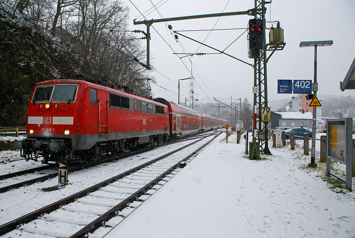 Heute hat es etwas geschneit und es schneit noch.... 
Die 111 168-1 (91 80 6111 168-1 D-DB) der DB Regio NRW rauscht am 19.01.2023 mit dem RE 9 rsx - Rhein-Sieg-Express (Aachen – Köln – Siegen), etwas verspätet durch den Bahnhof Scheuerfeld (Sieg) in Richtung Betzdorf.

Die Lok wurde 1980 von Henschel & Sohn in Kassel unter der Fabriknummer 32441 gebaut. Aktuell wird sie DB Gebrauchtzug am Markt zum Kauf angeboten.