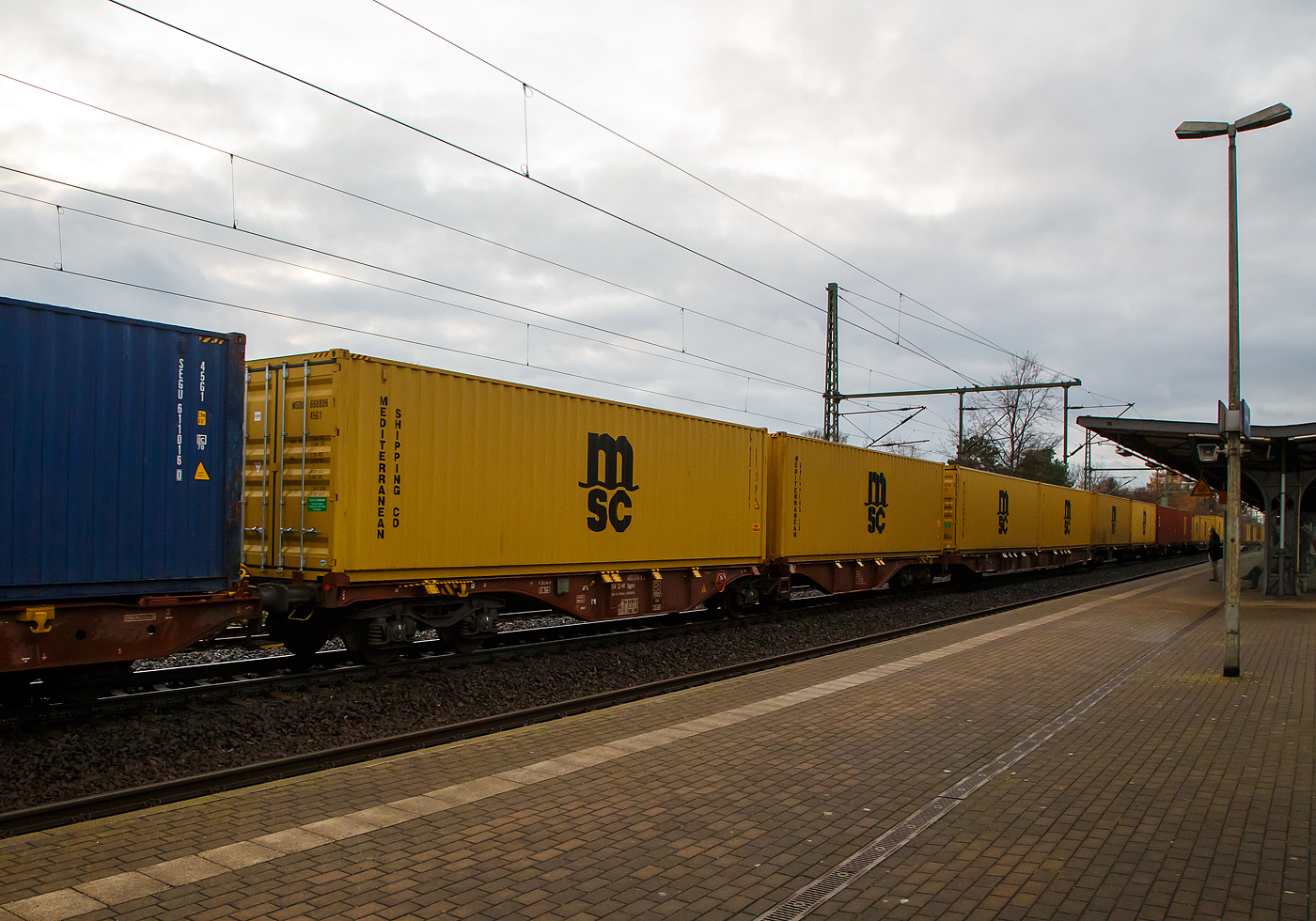 Hier sieht man den Unterschied der Gattung Sggrs (wie hier) und der Gattung Sggnss-XL (vorheriges Bild).....
6-achsiger Gelenk-Containertragwagen 33 54 4803 015-5 der Gattung Sggrs, der METRANS Rail s.r.o. (Prag / Praha), am 07.12.2022 im Zugverband, beladen mit zwei 40ft-Containern bei einer Zugdurchfahrt in Dresden-Strehlen.

Diese Wagen haben eine Länge über Puffer von 26.290 mm

Gattungs-Kennbuchstaben bedeuten:
S  -  Drehgestell-Flachwagen in Sonderbauart
gg -  Für Container mit einer Gesamtlänge von höchstens bis 80 Fuß
r  -  Gelenkwagen
ss -  Höchstgeschwindigkeit 120 km/h (beladen)
