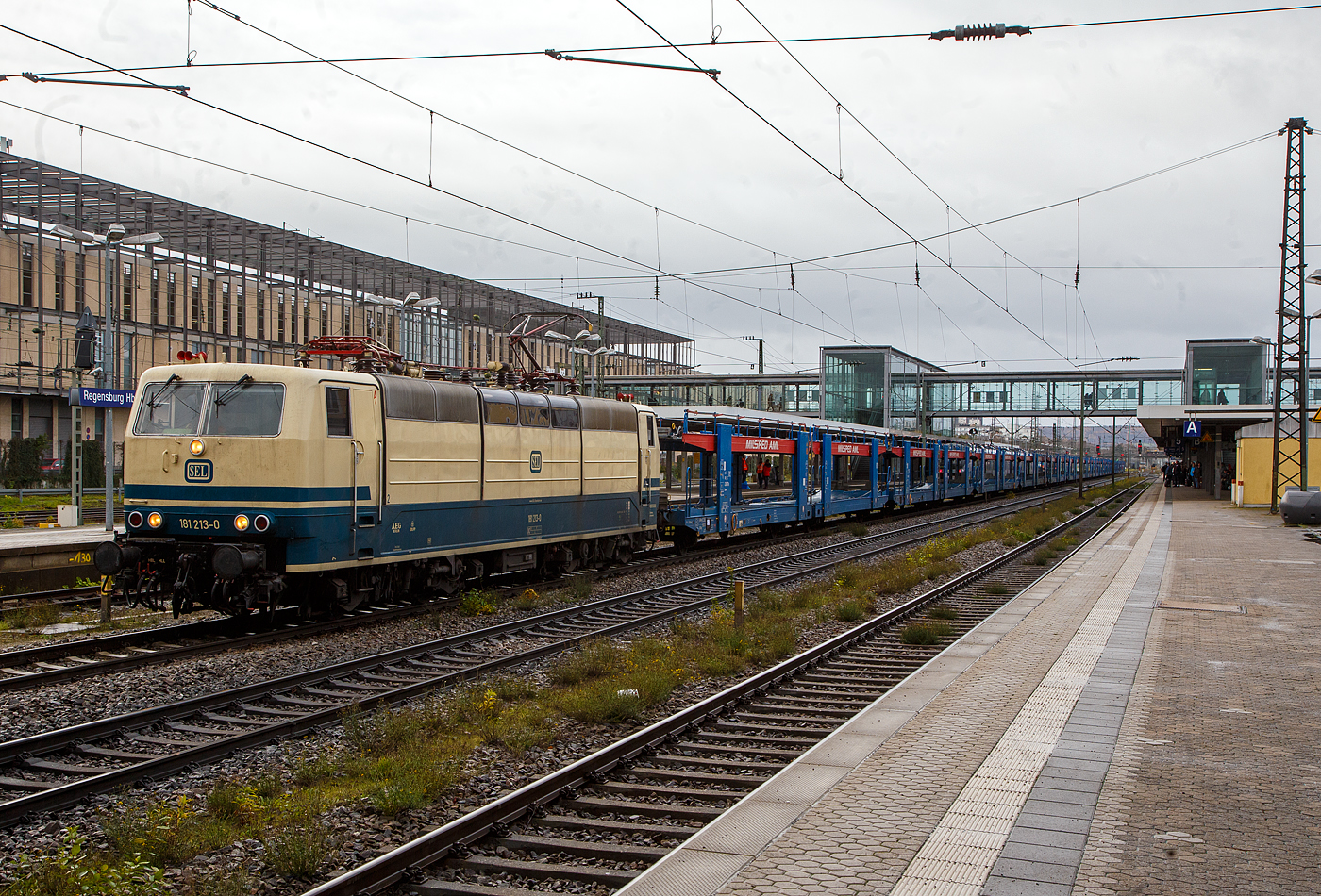 In ozeanblau/beige, die 181 213-0 (91 80 6181 213-0 D-SEL), ex DB 181 213-0 „Saar“ fährt am 24.11.2022 mit einem leeren Autotransportzug der serbischen Milsped AML (2 x2 achsige Wageneinheiten der Gattung Laaers, eingestellt mit B-MIL in Belgien) durch den Hauptbahnhof Regensburg, vermutlich in Richtung Straubing bzw. Passau.

Die Lok wurde 1974 bei Krupp in Essen unter der Fabriknummer 5279 gebaut, der elektrische Teil bei AEG unter der Fabriknummer 8850. Sie hat die Zulassung für Deutschland / Frankreich / Luxemburg. Im Jahr 2020 wurde sie an die Martin Schlünß Eisenbahnlogistik in Wankendorf verkauft. Sie hat nun wieder ein Farbkleid in ozeanblau/beige.
