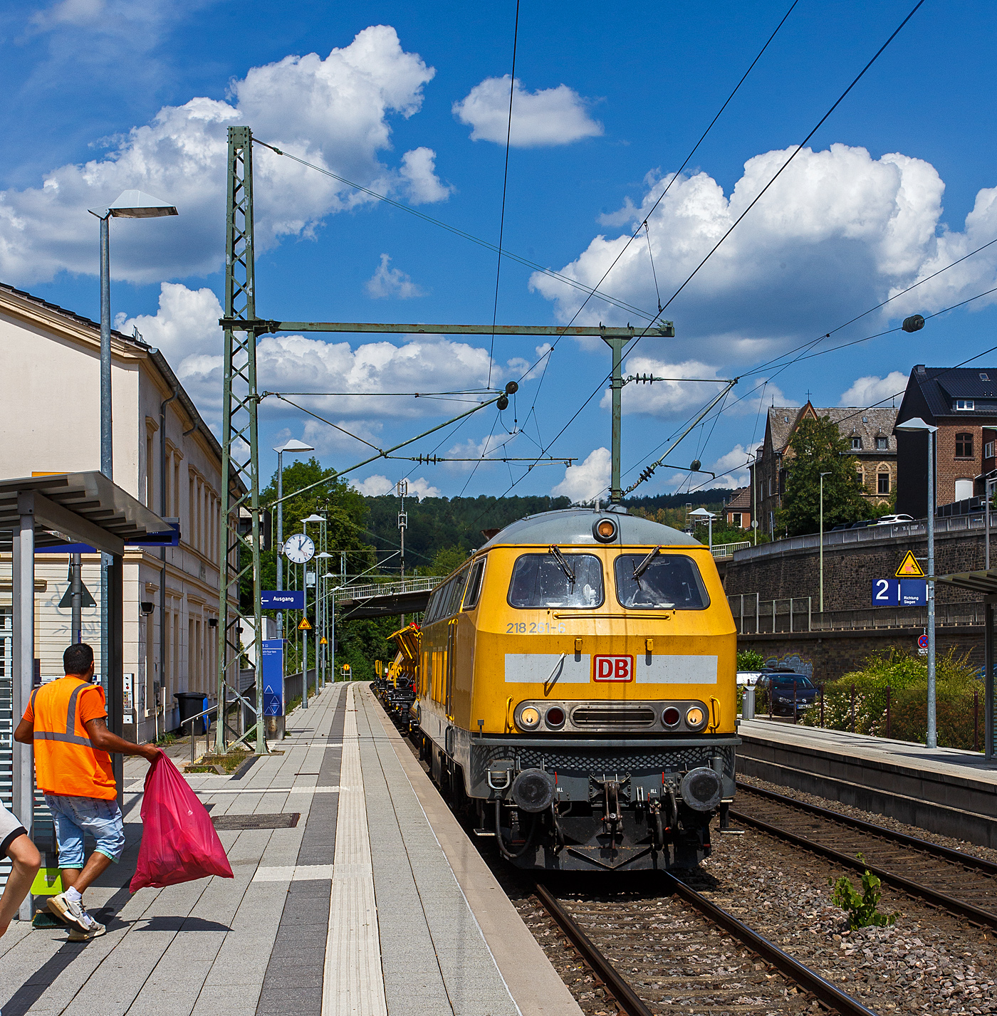 Leider stand ich hier auf dem falschen Bahnsteig. Die V164 Streckendiesellokomotive 218 261-6 (92 80 1218 261-6 D-DB) der Bahnbau Gruppe (DB Gleisbau) f�hrt am 13 Juli 2026 mit drei Weichentransportwagen (WTW 851, 850 und 852) durch den Bahnhof Kirchen (Sieg) in Richtung K�ln. 

Die V 164 wurde 1973 bei Henschel in Kassel unter der Fabriknummer 31738 gebaut und an die DB geliefert, seither wird sie auch als 218 261-6 bezeichnet. Im November 2008 wurde sie z-gestellt und dann an die Deutsche Bahn Gleisbau GmbH verkauft.