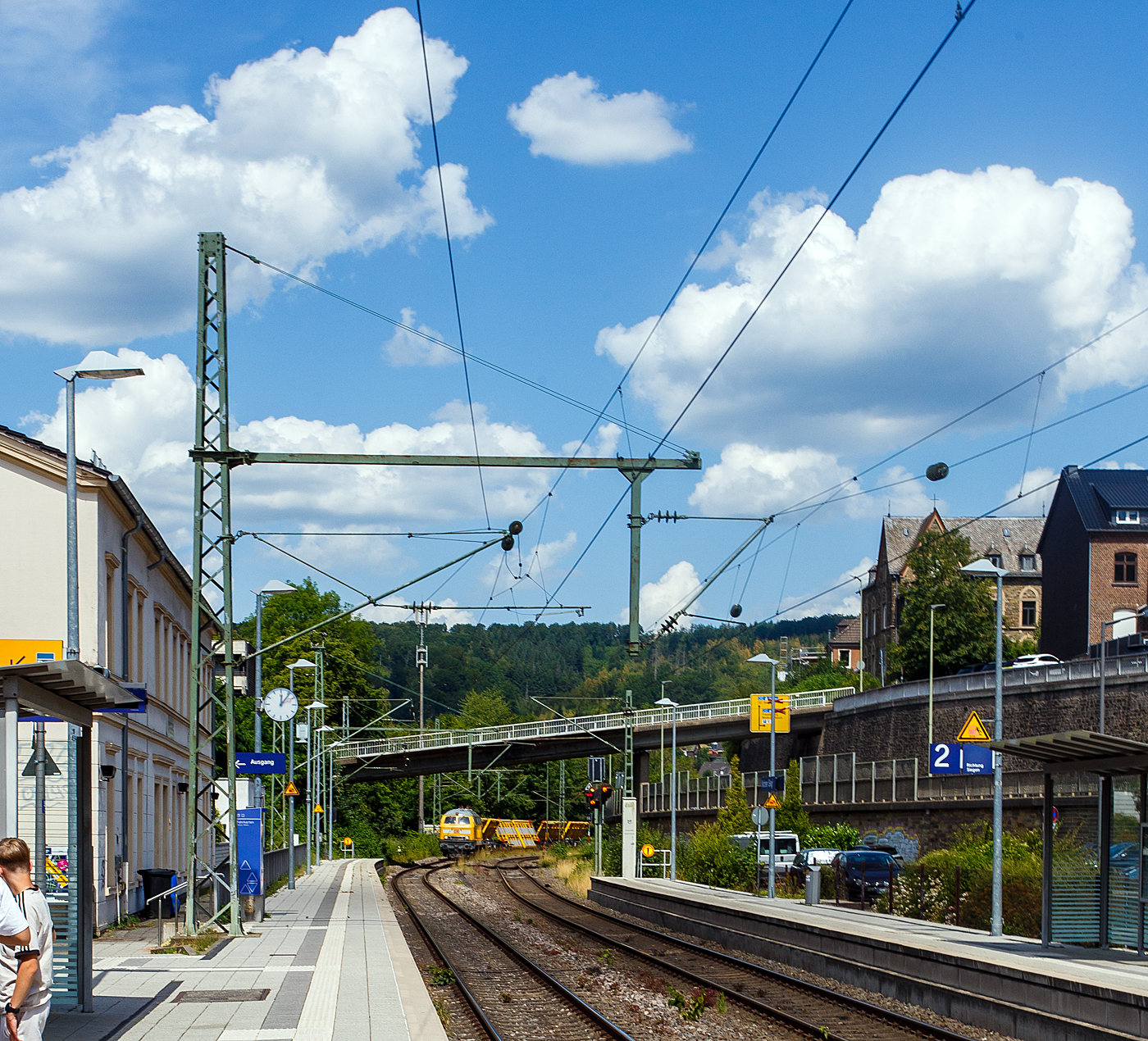 Leider stand ich hier auf dem falschen Bahnsteig. Die V164 Streckendiesellokomotive 218 261-6 (92 80 1218 261-6 D-DB) der Bahnbau Gruppe (DB Gleisbau) f�hrt am 13 Juli 2026 mit drei Weichentransportwagen (WTW 851, 850 und 852) durch den Bahnhof Kirchen (Sieg) in Richtung K�ln. 