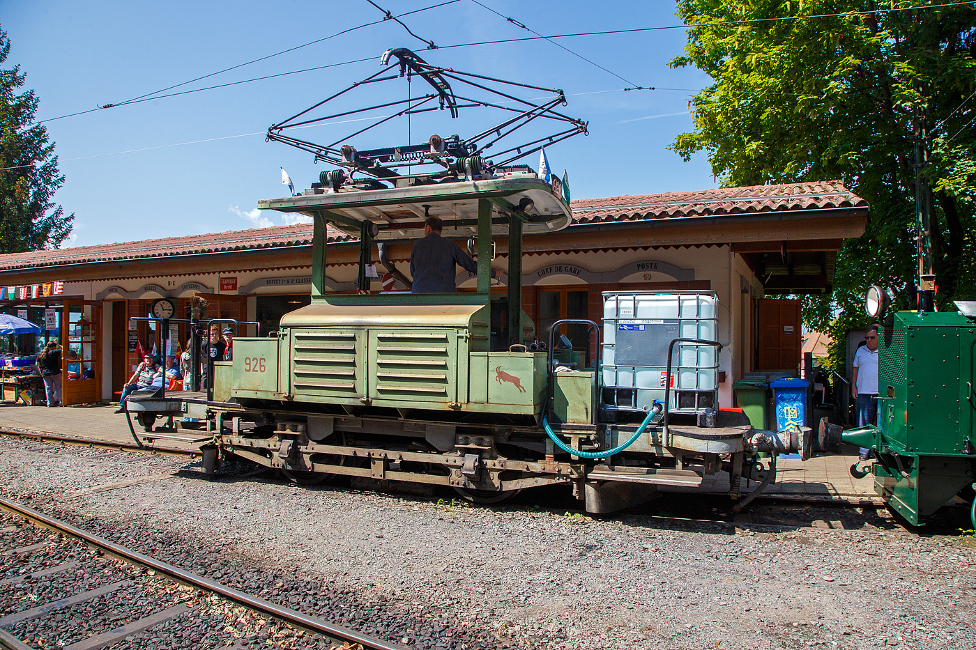 Mit einem 1m³-Wassertank und einer Motorspritze ausgestatte, als Löschzug, der Te 2/2 926 der Museumsbahn Blonay-Chamby, ex VBZ (Verkehrsbetriebe Zürich) Schienentraktor Xe 2/2 – 1926, ex Xe 2/2 – 926, ex StStZ Xe 2/2 – 926, der Museumsbahn Blonay-Chamby am 27.05.2023 im Museum Chaulin. 

Der Te 2/2 Schienentraktor wurde 1935 von der damaligen Städtische Straßenbahn Zürich (StStZ) selbst gebaut, der elektrische Teil ist von der Maschinenfabrik Oerlikon (MFO). Gebaut worden sind, zwische1930 und 1935, drei dieser Rangiermaschinen Nr. 924-926 (ab 1946 in Nr. 1924 bis1926), dabei wurden Untergestell, Elektrik und Motoren von Ce 2/2 Triebwagen der Serie 57-84 (mit markantem Peckham-Untergestell) verwendet. 

Die drei Manövrierwagen von erhielten zur Erleichterung der Fahrtrichtungswechsel von Anfang an einen Pantografen statt des umständlichen Lyrabügels. Die Rangierer fügten in den Depots den Triebwagen für die Hauptverkehrszeit die Beiwagen zu. Die Führerstände waren längs eingebaut, mit freier Sicht auf die Kupplungen, so konnte man mit ihnen sozusagen millimetergenau anfahren. Ihr grüner Anstrich und das charakteristische Fahrverhalten trugen ihnen den Spitznamen „Laubfrosch“ ein.

Speziell für Zürich war die große Flotte von Rangierfahrzeugen. Diese hatten die Aufgabe, für die Stoßzeit Verstärkungswagen beizustellen und danach wieder von den Tramzügen abzuziehen. Dazu gehörten auch Fahrten zwischen dem zugeteilten Depot und den Bereitstellungsgleisen an Wendeschleifen. Ende der 1960ziger Jahre wurde, durch die große Zahl angeschafften Mirage-Gelenkzüge, die Flotte von 24 Stück Rangierfahrzeugen überflüssig. Das Beistellen und Abziehen von Tramanhängern vor und nach der Stoßzeit war nun überflüssig. So war 1969 war ihre Zeit abgelaufen. Während die beiden Xe 2/2 1924 und 1025 Stück abgebrochen wurden, übergab die Stadt Zürich Xe 2/2 1926 an die eben im Aufbau begriffene Museumsbahn Blonay - Chamby BC. Dort leistete das gut unterhaltene und sehr bewegliche Triebfahrzeug wertvolle Dienste bei der Wiederinbetriebnahme der Strecke und beim Bau des Depots. Heute wird der „Laubfrosch“ mit seiner alten Zürcher Nummer 926 bestimmungsgemäß als Rangierfahrzeug auf dem Depotareal der BC benutzt. Hier kann der Laubfrosch seine Stärken ausspielen. Für den Einsatz auf der Museumsbahn musste Xe 2/2 926 die +GF+-Kupplung gegen eine herkömmliche Mittelpufferkupplung tauschen. Um den Betrieb unter der Spannung von 1000 V DB (MOB-GFM) zu ermöglichen, wurde ein zusätzlicher Widerstand montiert, die Straßenbahn Zürich fuhrt ja unter 700 V DC. Trotz der zusätzlichen Widerstände leistet er sehr gute Arbeitet bei der BC. Bei der Museumsbahn Blonay–Chamby tägt der Te 926 nicht den Spitznamen „Laubfrosch“ sondern „Le Bouc“ (Der Bock).

Hier wurde das Fahrzeug präventiv als Löschfahrzeug, für evtl. Bekämpfung von Böschungsbränden nach Funkenwurf durch die Dampflokomotive, vorgehalten. Gelegentlich rückt die BC Xe 2/2 926 mit dem Sprengwagen Xe 2/2 1, ex Straßenbahn Biel aus, der noch nicht wieder mit Fahrmotoren ausgerüstet ist.

TECHNISCHE DATEN:
Spurweite: 1.000 mm (Meterspur)
Gewicht: 9,3 t
Höchstgeschwindigkeit: 36 Km/h
Leistung: 2 x 44 kW = 88 kW (120 PS)
Triebraddurchmesser: 840 mm (neu)
Getriebeübersetzung: 1:4,277
Spannung: (ursprünglich) 700 V DC, bei der BC 1000 V DC

Quellen: BC, Drehscheibe
