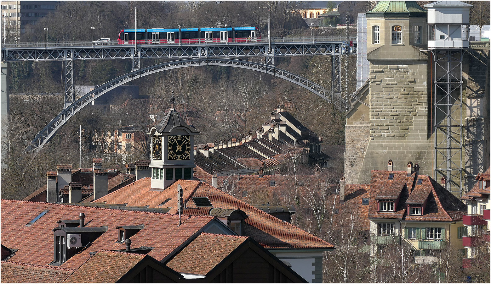 Mit Peter unterwegs durch Bern - 

Ein Combino Advanced Tram auf der Kirchfeldbrücke. Unten Teile des Stadtquartiers Matte mit den in Richtung Brücke ansteigenden Dächern der Häuser in der Badgasse. Rechts der Aufzug hinauf zum Münsterplateau.

07.06.2025 
