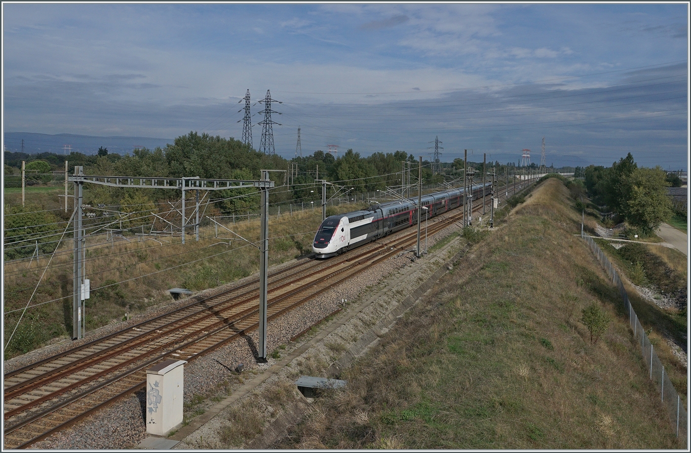 Nördlich von Bollène führt eine Strasse über die Rhone und in der Folge über zwei Brücken nach Lapalud. Die beiden Brücken führen einerseits über die LGV 75200 LN5 und kaum zwanzig Meter danach über die Strecke 830000 Paris - Marseille. Nun ist der Blick in Richtung Norden gerichtet und das Bild zeigt den SNCF INOIU TGV 6871 von Toulouse nach Lyon mit dem Rame 257 auf der Schnellfahrstrecke 752 000 LGV Méditerranée LN5 bei Km 577.2 auf der Fahrt in Richtung Norden. Links im Bild sind die Gleichstromfahrleitungsmasten der  Linken Rhonestrecke  830000 Paris Marseille zu erkennen. 1. Oktober 2024