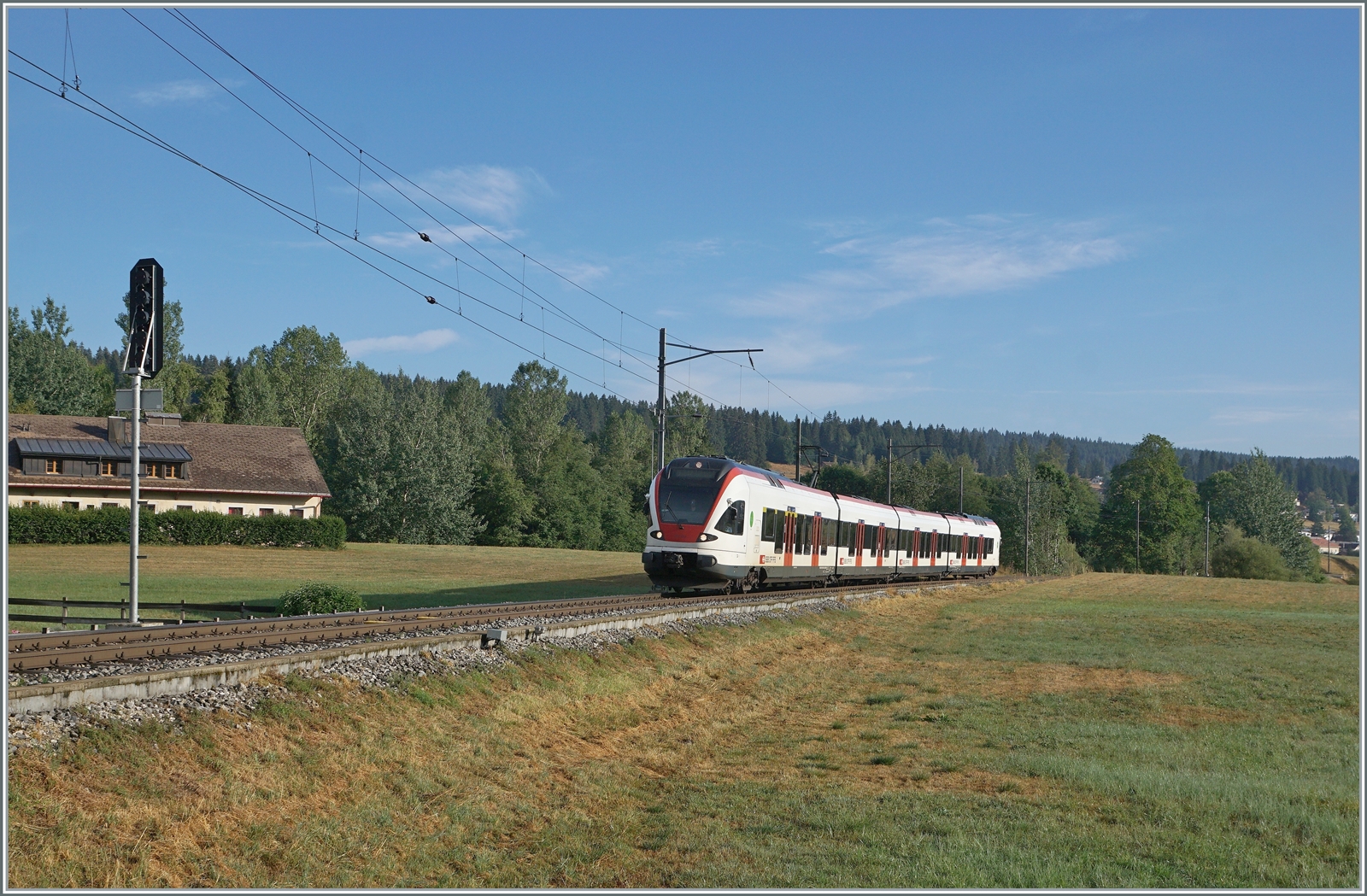 Nun haben auch wir unsere  Drei-Seen-Bahn : Die RER VAUD S2 Verbindung von Aigle nach Le Brassus verbindet nicht nur recht kontrastreiche Landschaften, sie führt auch an drei Seen entlang: dem Lac Léman, dem Lac de Brent und dem Lac de Joux. A propos Wasser: Während der Genfersee durch die Rhone ins Mittelmeer mündet, entwässert sich die Orbe in die Nordsee, der wenige Kilometer westlich von hier entspringende Doubs hingegen ins Mittelmeer. Das Bild zeigt den SBB RABe 523 022-7 (RABe 523 94 85 0 523 022-7 CH-SBB) als S2 24216 von Aigle beim Einfahrsignal von Le Brassus. 

15. August 2022