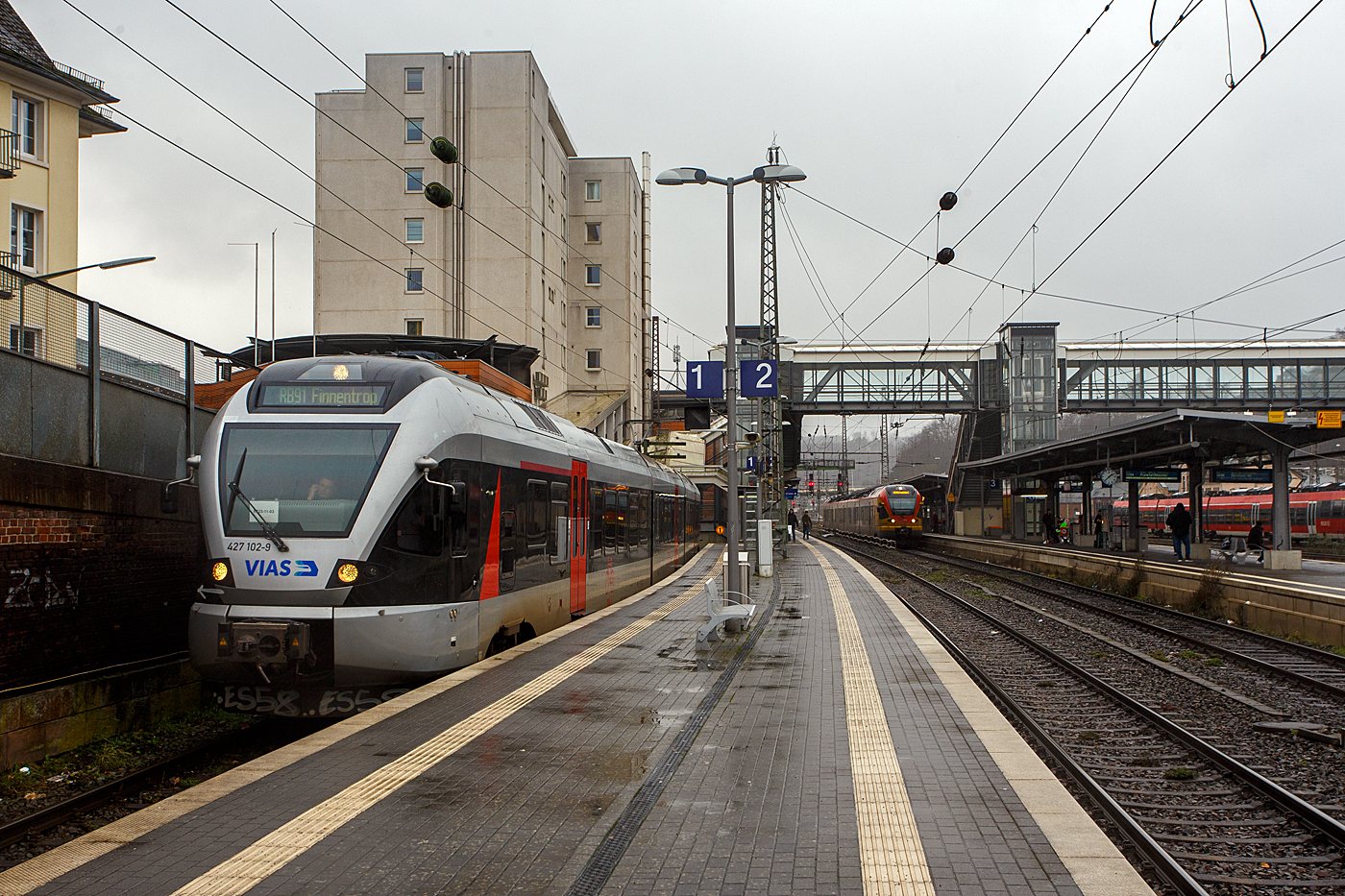 Nun mit VIAS-Logo.... 
Der (nun) VIAS Stadler FLIRT ET 23-11-03 (94 80 0427 102-9 D-VIASR / 94 80 0827 102-5 D-VIASR / 94 80 0427 602-8 D-VIASR), ex DB, ex Abellio Rail NRW ET 23 2103  Werdohl ,  ex ET 23 003, steht am 29 Dezember 2023, als RB 91  Ruhr-Sieg-Bahn  nach Finnentrop, auf Gleis 1 im Hauptbahnhof Siegen zur Abfahrt bereit.

Vom 9. Dezember 2007 bis zu seiner Insolvenz im Juli 2021 führte Abellio Rail NRW den Schienenpersonennahverkehr auf dem Ruhr-Sieg-Netz (RE 16 und RB 91) aus. Nach der Insolvenz übernahm zunächst per Direktvergabe wieder DB Regio mit dem Verkehr auf der Strecke bis Dezember 2023, seit dem Fahrplanwechsel im Dezember 2023 hat nun nach regulärer Vergabe schließlich die VIAS Rail GmbH den Schienenpersonennahverkehr (RE 16 / RB 91) bis Dezember 2034 übernommen.  VIAS Rail ist ein 100 %iges Tochterunternehmen der R.A.T.H.-Gruppe.

In Zusammenhang mit dem Neubau der Rahmedetalbrücke auf der A45 wurde die Nahverkehrsfreigabe der IC-Linie 34 zum 1. September 2022 auf den Abschnitt Dortmund–Iserlohn-Letmathe ausgeweitet, und seit dem 11. Dezember 2022 verkehrt in den Stunden ohne Intercity zwischen Siegen und Iserlohn-Letmathe anstelle der Linie RE 16 die neue Linie RE 34 (Dortmund-Siegerland-Express) betrieben durch die DB Regio, welche ebenfalls an Hagen vorbei nach Dortmund Hbf durchgebunden wird. So kann die Reisezeit zwischen Siegerland, Sauerland und Dortmund deutlich verkürzt werden. Eingesetzt werden neue Elektrotriebwagen des Typs Stadler Flirt 3 XL, aus aktuellen eigenen Beständen der S-Bahn Rhein-Ruhr.

Der FLIRT wurde 2007 von der Stadler Pankow GmbH in Berlin unter der Fabriknummer 34663 gebaut. Er wurde von Macquarie Rail (vormals CBRail) an die Abellio Rail NRW GmbH verleast bzw. vermietet. Im Jahr 2020 verkaufte Macquarie das Leasinggeschäft für Schienenfahrzeuge an die französischen Konkurrenten Akiem.
