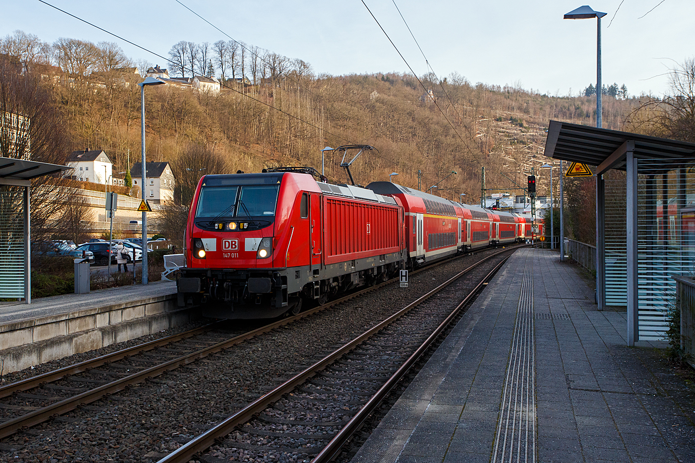 Nun verdrängen doch so langsam die neueren 147er (Traxx P160 AC3) die 146.0er (TRAXX P160 AC1) als Zugleistung des RE 9 - Rhein Sieg Express (RSX). Hier erreicht die 147 111-1 (91 80 6147 011-1 D-DB) der DB Regio NRW mit dem RE 9 - Rhein Sieg Express (RSX), von Aachen Hbf über Köln Hbf nach Siegen Hbf, am 22 Januar 2026 mit einer Verspätung von ca. 10 Minuten, den Bahnhof Kirchen/Sieg. Aber hier bekam er nochmals 10 Minuten aufgebrummt. Die Strecke wurde nicht frei und so hatte er hier länger Hp 0.

Die Bombardier Traxx P160 AC3 wurde 2016 von der Bombardier Transportation GmbH in Kassel unter der Fabriknummer 35105 gebaut und an die DB Regio Baden-Württemberg. So war sie von Dezember 2016 bis Juni 2020 in Stuttgart beheimatet. Im Juli 2020 ging sie an die DB Regio Nordost nach Berlin-Lichtenberg. Seit Mitte Dezember 2025 ist sie nun bei der DB Regio NRW. 

Eigentlich sollten schon die ganzen Leistungen übernommen haben, leider gibt es wohl noch Probleme mit der Software. Auch die Ausbildung bei der DB Regio NRW war etwas fehlerhaft, da sich die Lok alleine ganz anders als im Wendezugebetrieb verhält. Bleibt die Hoffnung das sich dies nun einpendelt.
