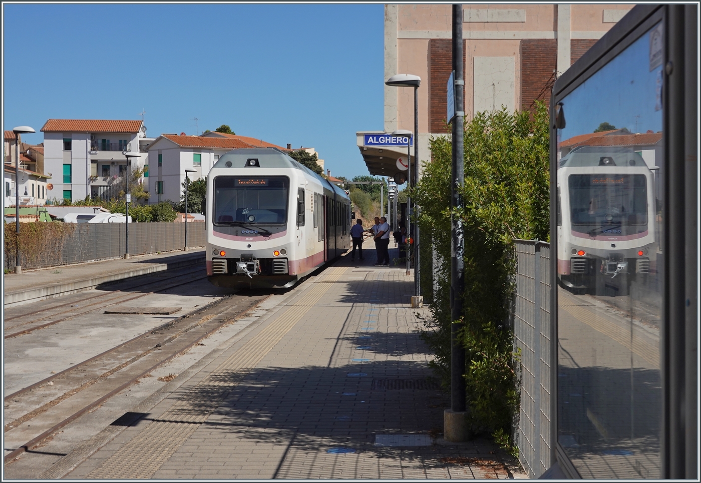 Nur kurze Zeit blieb f�r den Programmpunkt  Bahnfotografie Sardinen , danach schauten wir uns den wundersch�nen Ort Alghero an. Und zugegebenermassen muss ich festhalten, dass ein (mir von der Form her bekannter) Stadler Doppeldieseltriebwagen als Motiv kaum gelohnt h�tte noch l�nger am Bahnhof zu verweilen, immerhin versuchte ich in der halben Stunde den Zug in Szene zu setzen, wie z.B. hier mit dem kappen Spiegelbild im rechten Bildteil. Der Vollst�ndigkeit halber: In Alghero wartet der ARST (transporti regionali della sardegna) ADeS01 (95 83 4600 001-0 [A] / 95 83 4600 101-8 [B]) Doppeltriebwagen auf die Abfahrt als AT 70 nach S�ssari. 22. September 2026