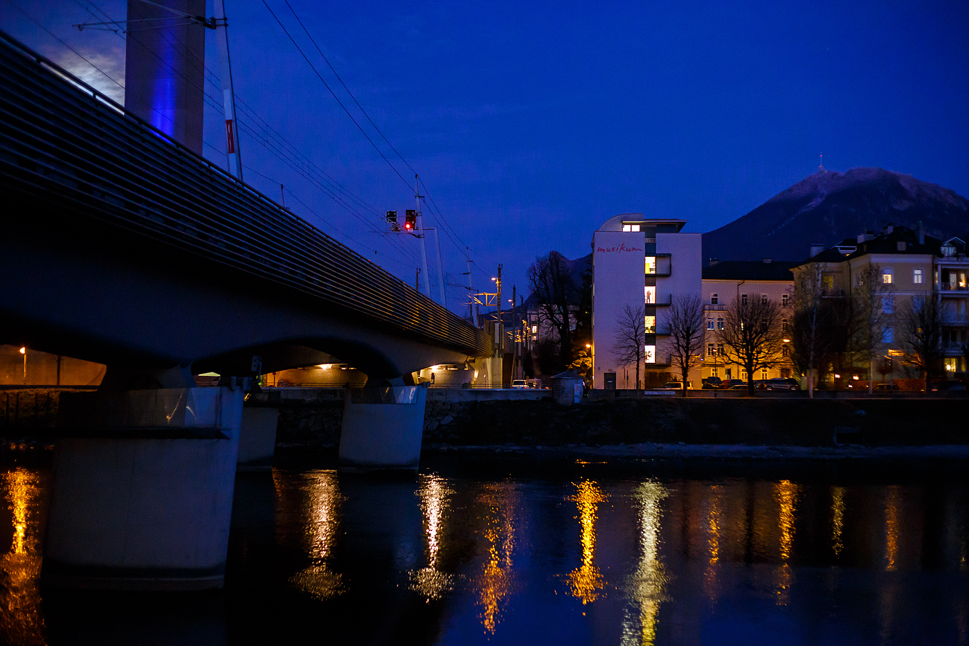 Salzburg by Night und Vollmond: Blick am 13 Januar 2025 von Station Salzburg Mlln-Altstadt in Richtung Hauptbahnhof, links die Eisenbahnbrcke ber die Salzach (der Bahnstrecke Salzburg - Rosenheim - BB 300), rechts im Hintergrund der 1.287 m hohe Gaisberg.