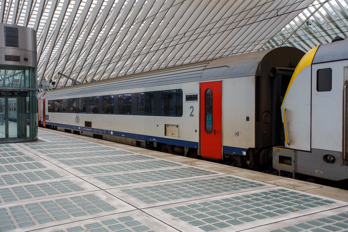 SNCB/NMBS - I11 Reisezugwagen der 2. Klasse, Bpm 61 88 20-90 020-6 B-B, ex 12820, eingereiht vor der Schluss-Lok im Zugverband eines IC von Ostende nach Eupen, am 21 Oktober 2025 im Bahnhof Liège Guillemins (Lüttich-Guillemins).

Als I11-Wagen werden Reisezugwagen der Nationale Gesellschaft der Belgischen Eisenbahnen (französisch SNCB - Société nationale des chemins de fer belges / niederländisch NMBS - Nationale Maatschappij der Belgische Spoorwegen) bezeichnet. Diese Wagen wurden zwischen 1995 und 1997 von Bombardier Transportation, im ehemaligen BN Constructions Ferroviaires et Métalliques in Brügge, gebaut. Die I11-Wagen waren die ersten Reisezugwagen der NMBS/SNCB, die für eine Geschwindigkeit von 200 km/h ausgelegt waren. Diese Geschwindigkeit wird planmäßig auf der Schnellfahrstrecke HSL 2 zwischen Brüssel und Lüttich ausgefahren. Bei 200 km/h liegt der Geräuschpegel bei 65 dB.

TECHNISCHE DATEN:
Hersteller: Bombardier Transportation (ex BN)
Spurweite: 1.435 mm (Normalspur)
Anzahl der Achsen: 4 
Länge über Puffer: 26.400 mm
Drehzapfenabstand: 18.400 mm
Achsabstand im Drehgestell: 2.560 mm
Drehgestelltyp: ANF Typ 36
Wagenkastenbreite: 2.860 mm
Eigengewicht: 46 t 
Höchstgeschwindigkeit: 200 km/h
Sitzplätze: 80 in der 2. Klasse Wagen 
Fahrradstellplätze: 2
Toiletten: 2 (Vakuum, geschlossenes System)