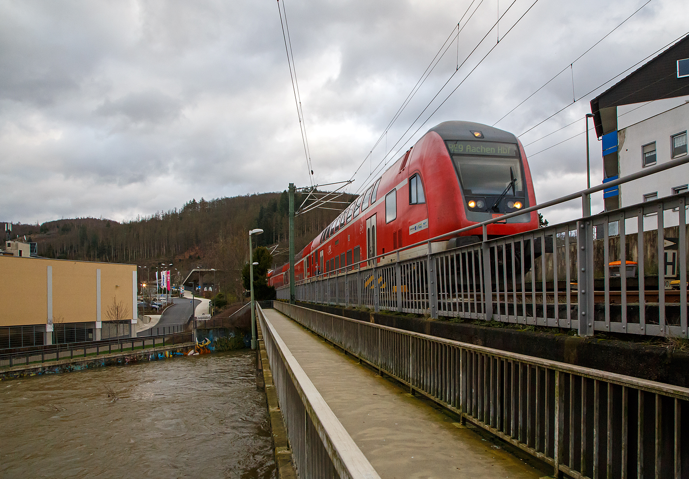 Steuerwagen voraus überquert der RE 9 rsx - Rhein-Sieg-Express (Siegen– Köln - Aachen) am 15.01.2023, die Siegbrücke und erreicht den Bahnhof Betzdorf (Sieg), Schublok war die 146 004-7 (91 80 6146 004-7 D-DB).

Links sieht man die Sieg die z. Z. mächtigen Wassermassen führt, die Hochwassermeldemarke ist schon seit Tagen hier erreicht.
