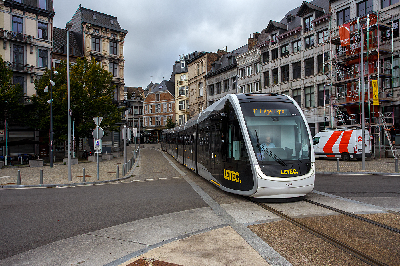 Stra�enbahn L�ttich der Triebwagen LETEC 5120, ein siebenteiliger niederfluriger und klimatisierter Zweirichtungs-Stra�enbahnwagen des Typs CAF Urbos 100 des spanischen Herstellers Construcciones y Auxiliar de Ferrocarriles (CAF), kommt am 01 September 2026, als Linie T1 nach Li�ge Expo, durch die Rue de la Cit� und erreich so gleich die an der Maas gelegene Haltestelle La Batte. Hier im Abschnitt Op�ra – Curtius gibt es keine Fahrleitung, so erfolgt die Fahrt mittels der im Fahrzeug eingebauten Traktionsbatterien. 

Die Stra�enbahn L�ttich (Tram de Li�ge, wallonisch Tram di Lidje) ist die Stra�enbahn der (belgischen) wallonischen Stadt L�ttich. Sie wurde am 28. April 2025 er�ffnet und wird vom wallonischen Verkehrsunternehmen Op�rateur de transport de Wallonie (OTW) als Teil von Transport en Commun (TEC) betrieben. Die Bereitstellung und Wartung der Fahrzeuge sowie der Infrastruktur erfolgt durch Tram Li�ge Maintenance S.A., einem Tochterunternehmen von Construcciones y Auxiliar de Ferrocarriles (CAF) und Colas Rail. Zuvor existierte bereits von 1871 bis 1968 eine Stra�enbahn in L�ttich.

Die Stra�enbahn f�hrt auf der Spurweite 1.435 mm (Normalspur) unter Oberleitung mit einer Spannung von 750 V DC (Gleichstrom), gro�e Teilst�cke werden im Batteriebetrieb ohne Oberleitung befahren. Die nicht elektrifizierten Abschnitte sind G�n�ral Leman–Blonden, Op�ra – Curtius und Pont Atlas–Droixhe. Es gibt eine Linie auf einer Streckenl�nge von 11,7 km von Sclessin/Standard bis Coronmeuse bzw. Li�ge Expo (wo sich auch das Depot befindet). Bei Pont Atlas zweigt die Strecke ab, so fahren die Triebwagen von dort abwechselnd Coronmeuse oder Li�ge Expo an. Die H�chstgeschwindigkeit des Systems liegt bei 50 km/h. Auf den meisten Streckenabschnitten gelten jedoch geringere Begrenzungen.

Die Triebwagen:
Das Konsortium Tram'Ardent stellt 20 siebenteilige, niederflurige, klimatisierte Zweirichtungs-Stra�enbahnwagen des Typs Urbos 100 des spanischen Herstellers Construcciones y Auxiliar de Ferrocarriles (CAF) f�r die Stra�enbahn L�ttich (Tram de Li�ge) zur Verf�gung. Die Zweirichtungswagen sind 45,41 Meter lang, 2,65 Meter breit und haben ein Eigengewicht von 64 t. Sie bestehen aus den Modulen C1-S1-M-S3-R-S2-C2 und besitzen acht T�ren pro Seite und bieten 62 Sitze bei einer Gesamtkapazit�t von 372 Fahrg�sten. Die ersten Fahrzeuge trafen Mitte 2022 in L�ttich ein.

Als Urbos bezeichnet die baskische Firma Construcciones y Auxiliar de Ferrocarriles (CAF) ihre seit 2002 gefertigten niederflurigen Stra�enbahnwagen. Nachdem die ersten Fahrzeugserien der Generationen Urbos 1 und Urbos 2 vor allem an spanische Betriebe geliefert wurden, �berwiegt mit den Urbos 3 inzwischen der Exportanteil. 

Die Variante Urbos 100 ist die am h�ufigsten verkaufte und vollst�ndig niederflurig. In der Standardausf�hrung ist sie als Multigelenkwagen mit kaltgef�gter Karosserie aus rostfreiem Stahl und Aluminium, mit Losrads�tzen und voll abgefedertem, auf einzelne R�der wirkendem Antrieb ausgef�hrt

TECHNISCHE DATEN:
Fahrzeugtyp: 100%�Niederflur�Gelenktriebwagen
Fahrzeugkonfiguration: 7-teiligen TW im Zweirichtungsbetrieb
Hersteller: Construcciones y Auxiliar de Ferrocarriles (CAF), Beasain (E)
Baujahre: 2022 und 23
Anzahl: 20 siebenteilige TW
Spurweite: 1.435 mm (Normalspur)
Achsfolge: Bo'+Bo'+2'+Bo'
Fahrzeugl�nge: 45.411 mm 
Fahrzeugbreite: 2.650 mm
Leergewicht: 64 t
T�ren (Doppelt�ren) pro Seite: 8
Sitzpl�tze:  62
Stehpl�tze: 310


