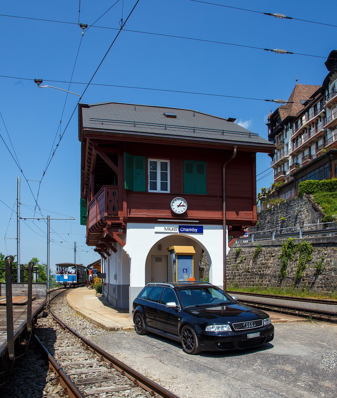 Über dem Genfersee, der Bahnhof Chamby am 27.05.2023.

Der Bahnhof Chamby ist ein Keilbahnhof, und liegt an der MOB (Montreux–Berner Oberland-Bahn) Strecke (KBS 120) Montreux–Montbovon–Zweisimmen, von hier zweigt die Strecke (KBS 115) nach Blonay ab, diese wird in der Sommersaison von der Museumsbahn, gehört aber der Transports Montreux–Vevey–Riviera (MVR, ex CEV). Hinter dem Bahnhofsgebäude der MOB befindet sich hier auch ein Ticketschalter der Museumsbahn BC. Links steht die G 2/2 Nr. 4 (020T) Krauss-Kastendampflok (Tramlok), der Museumsbahn Blonay–Chamby, mit dem vorgestellten zweiachsigen haboffenen Personenwagen (Sommerwagen) ex LCD C 21.
