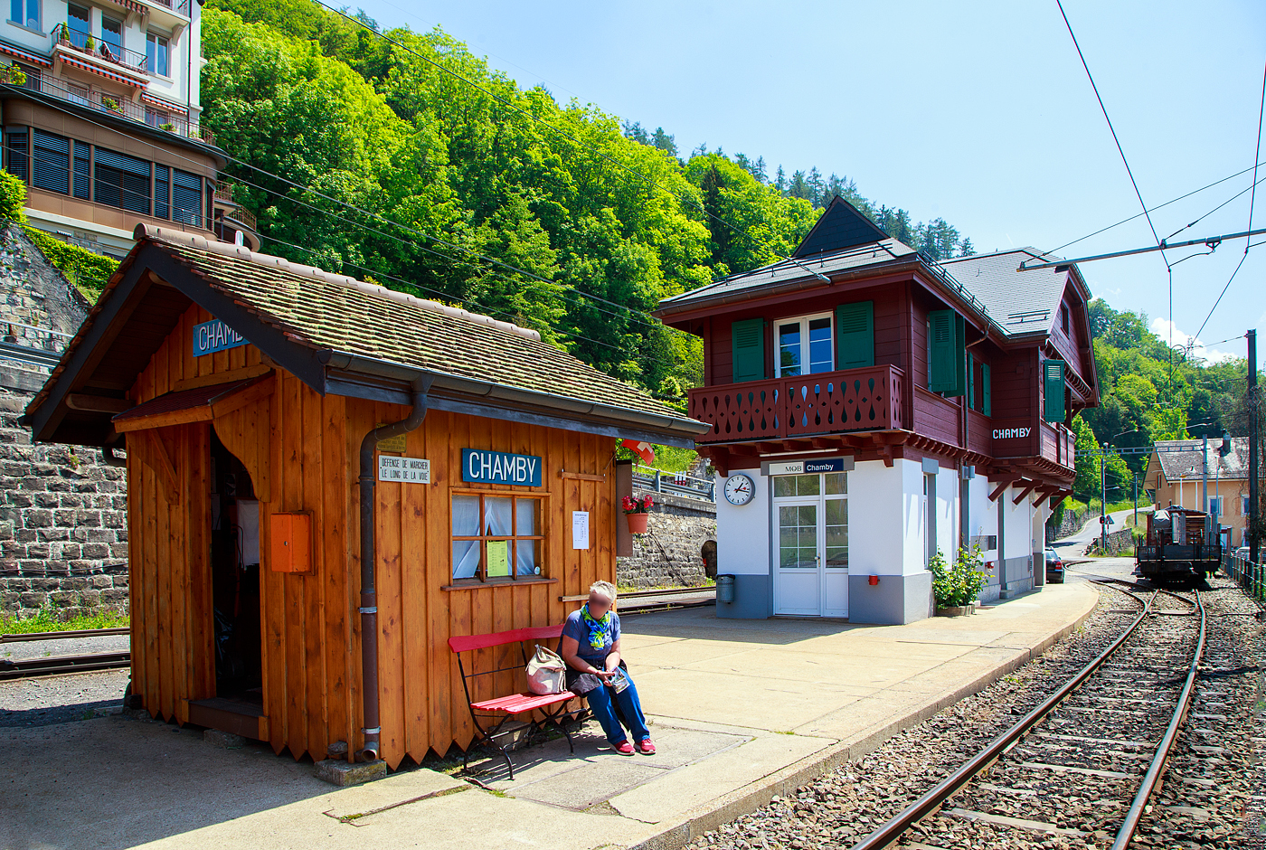 ber dem Genfersee, der Bahnhof Chamby am 27.05.2023.

Der Bahnhof Chamby ist ein Keilbahnhof, und liegt an der MOB (Montreux–Berner Oberland-Bahn) Strecke (KBS 120) Montreux–Montbovon–Zweisimmen, von hier zweigt die Strecke (KBS 115) nach Blonay ab, diese wird in der Sommersaison von der Museumsbahn, gehrt aber der Transports Montreux–Vevey–Riviera (MVR, ex CEV). 

Vor dem Bahnhofsgebude der MOB der Ticketschalter der Museumsbahn Blonay–Chamby.