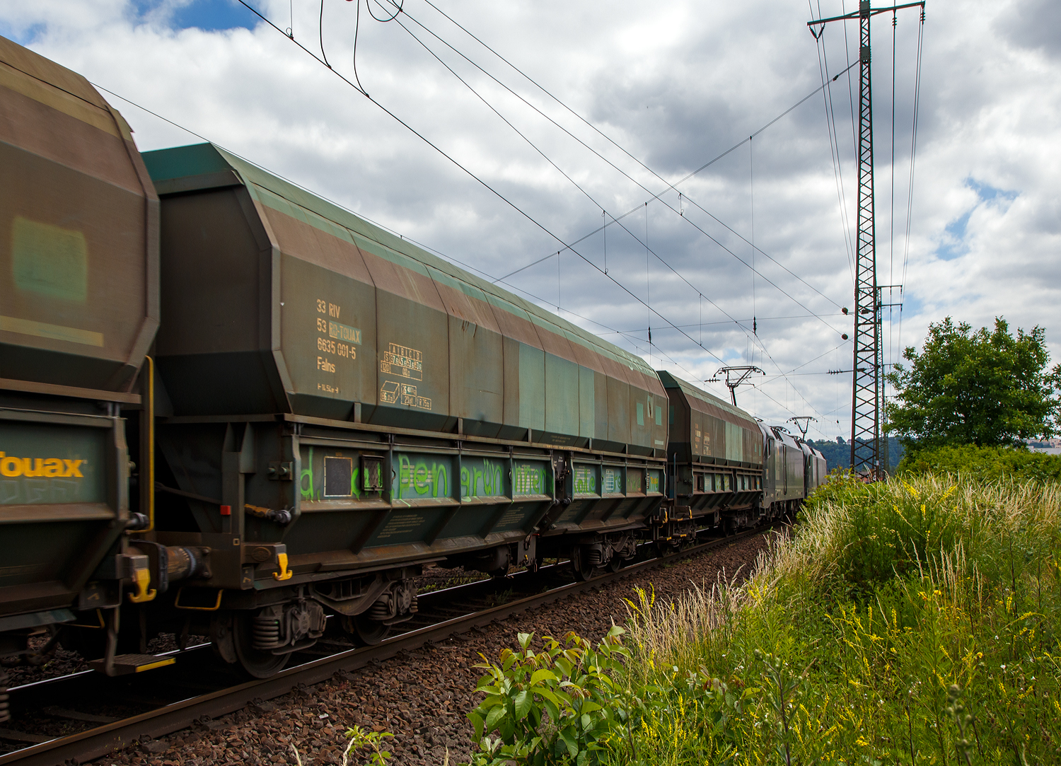Vierachsiger 86m³ offener Schüttgutwagen (Kohlewagen) mit schlagartiger Schwerkraftentladung und pneumatischer Klappenbetätigung, 33 53 6635 001-5 RO-TOUAX, der Gattung Falns 86 m³, der irländischen Vermietungsfirma TOUAX Rail Limited (in Rumänien eingestellt), eingereiht im Zugverband (gezogen von zwei 182er) bei der Zugdurchfahrt am 18. Juni 2017 durch Koblenz-Lützel in Richtung Süden.

TECHNISCHE DATEN:
Länge über Puffer: 14.540 mm (Normalspur)
Anzahl der Achsen: 4 (in 2 Drehgestellen)
Länge über Puffer: 14.540 mm
Drehzapfenabstand: 9.000 mm
Achsabstand im Drehgestell: 1.800 mm
Laufraddurchmesser: 920 mm (neu)
Max. Eigengewicht: 26.400 kg
Ladevolumen: 86 m³
Max. Ladegewicht: 63,6 t ab Streckenklasse D
Höchstgeschwindigkeit: 100 km/h (beladen) / 120 km/h (leer)
Beladung Öffnung: 12.800 mm x 1.957 mm
Entladung Öffnungen je Längsseite: 2 x 5.700 mm, je 610 mm hoch
Entladung per Schwerkraft, beidseitig, pneumatische Klappenbetätigung
Kleinster bef. Gleisbogenradius: R 75 m
Intern. Verwendungsfähigkeit: RIV
