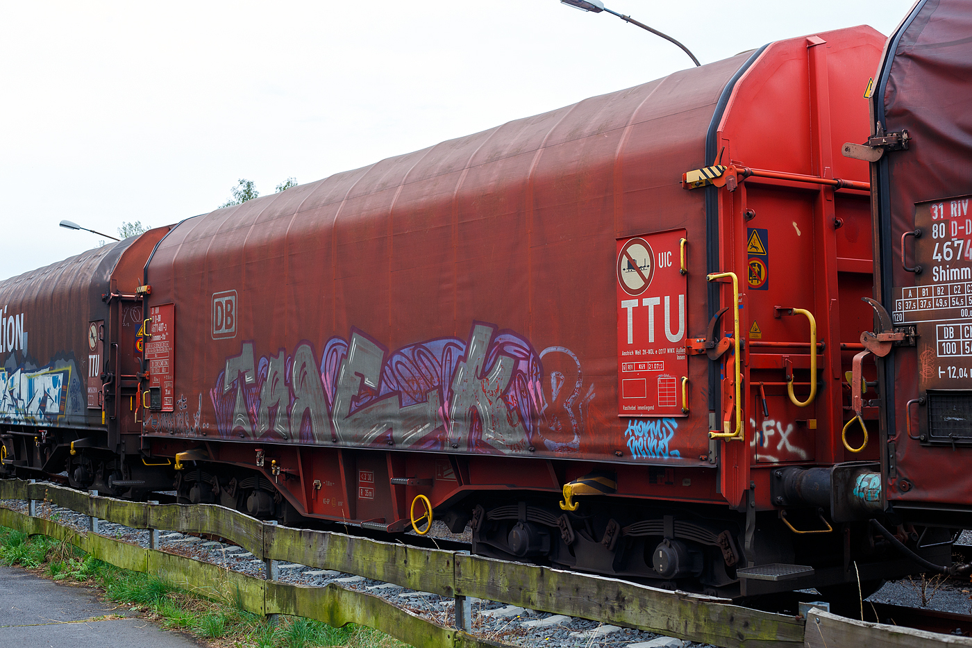 Vierachsiger Drehgestell-Flachwagen mit verschiebbarem Planenverdeck und Lademulden fr Coil-/Spaltbandtransporte 31 80 4671 407-3 D-DB, der Gattung Shimmns-ttu 708.4, der DB Cargo AG, abgestellt im Zugverband (bergabegterzug) am 26  September 2024 in Herdorf auf dem Rbf der Kreisbahn Siegen-Wittgenstein (KSW).

Der Wagen wurde1992 unter der Fabriknummer 1100, von LHB - Linke-Hofmann-Busch GmbH in Salzgitter-Watenstedt gebaut. Die Drehgestelle der Bauart LHB 82 (DB BA 589) mit Parabelfedern u.a. unter der Fabriknummer 42185. Ursprnglich waren die Wagen mit verschiebbaren Teleskophauben der Shimmns-u 708 ausgefhrt, ab 2018 werden die zu Wagen mit verschiebbarem Planenverdeck der Gattung Shimmns-ttu 708.4 umgebaut.

TECHNISCHE DATEN:
Spurweite: 1.435 mm (Normalspur)
Achsenanzahl: 4 (in 2 Drehgestelle)
Lnge ber Puffer: 12.040 mm
Lnge der Ladeflche: 10.800 mm
Drehzapfenabstand: 7.000 mm
Achsabstand im Drehgestell: 1.800 mm
Laufraddurchmesser: 920 mm (neu)
Eigengewicht: 20.000 kg
Hchstgeschwindigkeit: 100 km/h (beladen) / 120 km/h (leer)
Maximales Ladegewicht: 66,0 t (ab Streckenklasse D4), bei DB auch CM2 – 54,0t Max. Ladegewicht auf DB Netz auch: 54,0 t bei CM2 / 60,0 t ab CM3
Kleinster bef. Gleisbogenradius: 35 m
Bauart der Bremse: KE-GP (LL)
Bremssohle: IB 116
Handbremse: Ja
Intern. Verwendungsfhigkeit: RIV / G1
Hersteller der Plane: Schleswiger Tauwerkfabrik Oellerking GmbH & Co. KG
