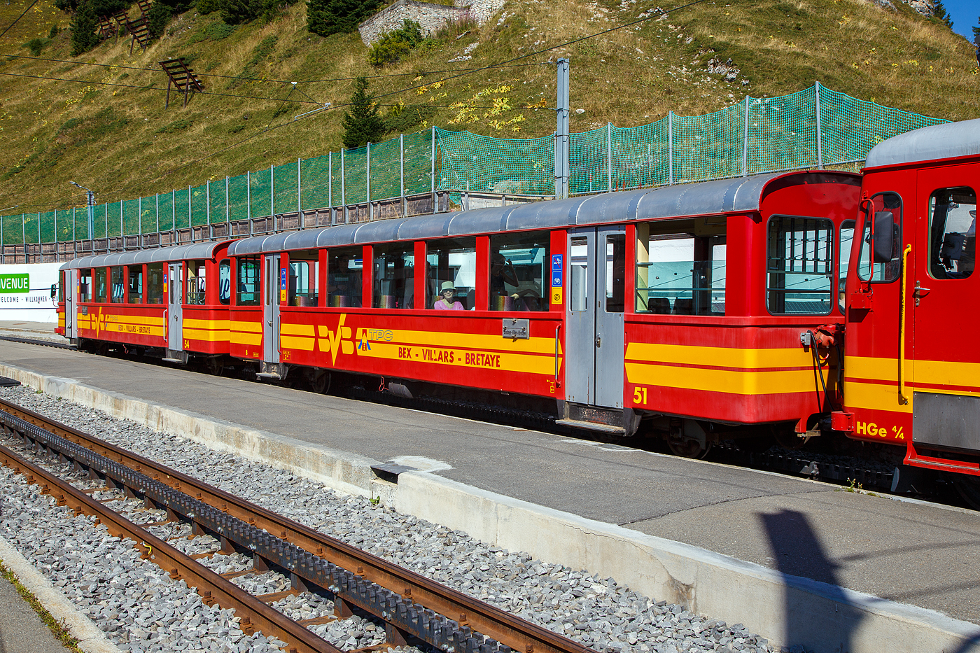 Vor der tpc BVB HGe 4/4 32 „Villars“ am 10 September 2023 im Bergbahnhof Col-de-Bretaye (1.808 m ü. M.), eingereiht in einen Personenzug, der Steuerwagen tpc BVB Bt 54 und der Personenwagen tpc BVB B 51.

Die vierachsigen Wagen wurden 1953 von der SIG (Schweizerische Industrie-Gesellschaft) in Neuhausen am Rheinfall gebaut, die Elektrik ist von der MFO (Maschinenfabrik Oerlikon).

Heute sind diese Garnituren nicht mehr im Planeinsatz. Hier an dem Wochenende (08 bis 10 September 2023) feiert die TPC 125 Jahre BVB! (Les TPC célèbrent les 125 ans du BVB!). So kamen auch historische Züge und Triebwagen zum Einsatz.