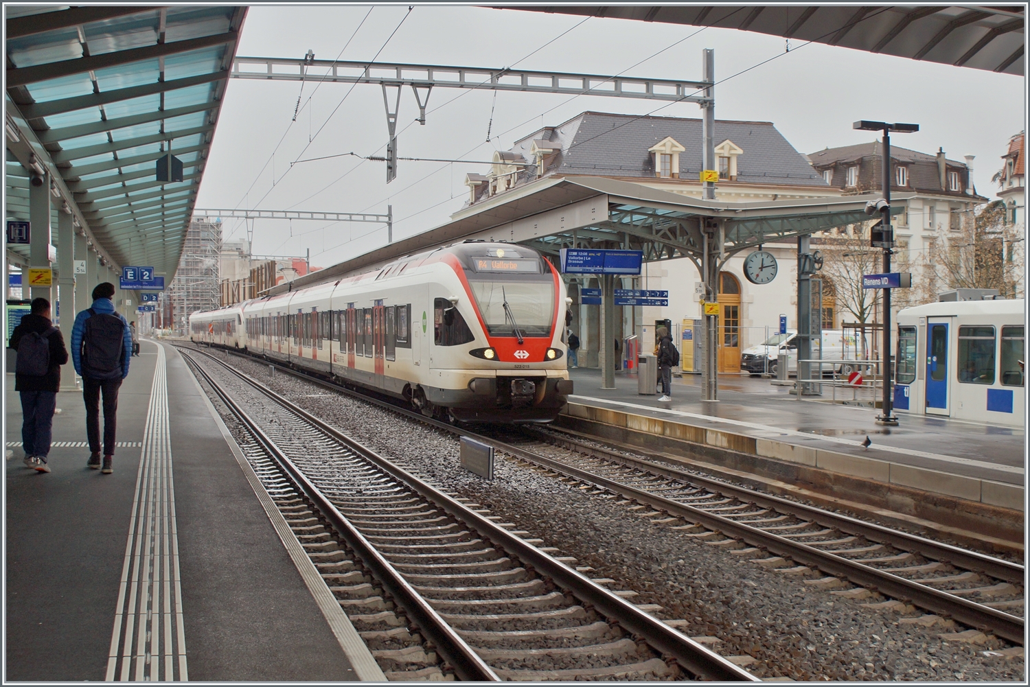 Zwei SBB Flirt, davon je ein RABe 523 und RABe 523.1 verlassen Renens nach Vallorbe und Le Brassus (Flügelzug). Im Hintergrund rechts im Bild ist ein TL TSOL Be 4/6 als m1 zu erkennen. 

14. Dez. 2023 