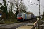 186 284 legt sich am 11.12.24 mit einem Containerzug auf dem Weg nach Krefeld am Bahn�bergang Viehgasse in Meerbusch in die Kurve.