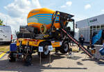 Die Weltneuheit im Gleisbau, der erste 2-Wege-Betonfahrmischer
Die railGOOD by Meykratec aus Bad Rothenfelde präsentierte auf der 29. Internationale Ausstellung Fahrwegtechnik 2025 (iaf) in Münster (hier am 20 Mai 2025) den GOODmix 3,5, einen Betonmischer mit Schienenfahrwerk. Eine Innovation auf die die Welt des Gleisbaus gewartet hat. Zugelassen ist er als Gleisfahrende Baumaschine G 9901 001 (Art: Zweiwege-Betonmischer GOODmix 3,5). Ich finde ein sehr gelungenes Gerät. 

Das Schienenfahrwerk des GOODmix 3,5 ermöglicht es dem Betonmischer sich mühelos auf den Gleisen zu bewegen, ohne dabei aufwändige Transportlösungen oder zusätzliche Maschinen zu benötigen. Dies spart nicht nur Zeit und Kosten, sondern erhöht auch die Flexibilität und Produktivität auf der Baustelle. 

Dank seiner robusten Bauweise und leistungsstarken Mischtrommel liefert der GOODmix 3,5 zuverlässig eine gleichmäßige und hochwertige Betonmischung, die den Anforderungen des Gleisbaus in jeder Hinsicht gerecht wird. 

Das Basisfahrzeug ist ein DIECI Fahrmischer vom Typ AB L 4700 T des italienischen Herstellers Dieci s.r.l. aus Montecchio Emilia. Das Schienenfahrwerk ist vom niederländischen Hersteller AMT aus Breda. Idee Entwicklung sind von railGOOD by Meykratec aus Bad Rothenfelde, die auch den Alleinvertrieb hat. 

Das Fahrzeug:
Der hydrostatische Antrieb mit Verstellpumpe, gewährleistet flüssige und genaue Bewegungen. Der unabhängige Hydraulikkreis für die Trommeldrehung garantiert maximale Mischleistungen. Die Mischtrommel verfügt zur einfacheren Entleerung über eine Hubeinrichtung, sowie ein 180°-Drehsystem für eine dreiseitige Entleerung. Die Fahrerkabine, die sich hinsichtlich Ergonomie, Komfort und Sicherheitsausstattungen im gehobenen Segment ansiedelt, ist mit einem umkehrbaren Fahrerstand ausgestattet, so kann der Fahrer immer in Fahrtrichtung sitzen.

Technische Merkmale:
Abmessungen in Transportstellung 5.825 x 2.400 x 3.140 mm
Eigengewicht: ca. 9.500 kg
Max. Nutzlast: 5.000 kg
Inhalt Wassertank: 630 l

Dieselmotor: Wassergekühlter 4 Zylinder Perkins-Dieselmotor mit Turbolader und Ladeluftkühlung, sowie Direkteinspritzung, vom Typ 904J-E36TA (Stage V)
Motorleistung: 85,6 kW (116 PS) bei 2.200 U/min
Maximales Drehmoment: 566 Nm – 1.500 U/min
Motorhubraum: 3,621 l (Bohrung Ø 98 mm x 120 mm Hub)
Höchstgeschwindigkeit Offroad: 27 km/h 

Auf der Schiene:
Inbetriebnahme: 07.01.2025
Spurweite: 1.435 mm (Normalspur)
Höchstgeschwindigkeit: 19,5 km/h (in Arbeitsstellung 5 km/h)
Zur Mitfahrt zugelassene Personen: 1 (Fahrer + 1 Rangierbegleiter)
Zugelassene Streckenklasse: A und höher
Laufraddurchmesser: 500 mm (neu)
Hydraulische Bremse auf allen vier Eisenbahnräder im Laufwerk
Federspeicherbremsen auf allen vier Eisenbahnräder im Laufwerk Durchmesser Schienenrad 500 mm
Max. Rampenwinkel 13,5°
Max. Überhöhung 200 mm
Fahrgeschwindigkeit Gleis Stufe 1 bis 9, Stufe 1 bis 2 9-19,5 km/h
Fahrgeschwindigkeit Offroad 27 km/h
