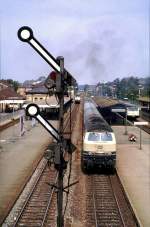 218 416-5 hat Ausfahrt aus Memmingen in Richtung Süden; auf Gleis 1 steht eine weitere 218 und am Bahnsteig Gleis der Vorserien-Triebzug 628 009-3; die Farben der Fahrzeuge sind entsprechend der