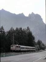 139 131-7 mit Nahverkehrszug bei Berchtesgaden mit dem Berg mit der  liegenden Hexe  im Hintergrund, leider bei sehr schlechten Lichtverhältnissen am 16.06.2000.