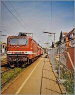 Die DB 143 640-1 beim Halt in Lörrach Stetten. Der Zug ist auf dem Weg nach Basel Bad. Bf. 

Analogbild vom August 2002