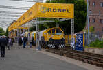 Die Robel Bahnbaumaschinen GmbH aus Freilassing (gehört zu Plasser & Theurer) präsentierte auf der 28. Internationale Ausstellung Fahrwegtechnik (iaf) in Münster (hier am 31.05.2022) das dreiteilige Schienenbearbeitungssystem ROMILL Urban 3 E³ für die Plasser American Corporation (PAC) mit Sitz in Chesapeake, Virginia. Die Lieferung soll im Sommer 2022 erfolgen. Das Schienenbearbeitungssystem ROMILL Urban E³ ist ein gemeinsames Projekt von Robel, Schweerbau International GmbH & Co.KG (SBI) und Vogel & Plötscher GmbH & Co.KG, es ist die weltweit erste Hybrid-Fräsmaschine von Robel. Die Firmen Schweerbau und SBI gehören auch zur Robel Holding GmbH, ex Deutsche Plasser Holding GmbH.

Fahrzeugdesign, Antriebs -und Frästechnologien der Romill Urban E³ wurden von SBI speziell für die U-Bahn Instandhaltung entwickelt. Die drei Einheiten sind für sehr kleine Lichtraumprofile, beispielsweise die der London Underground, ausgelegt und können somit in beinahe allen nordamerikanischen Tunneln eingesetzt werden. Der Hybrid-Antrieb, eine Kombination aus Batteriespeicher und Range-Extender über einen abgasreduzierten Dieselmotor, ermöglicht emissionsfreie Schienenbearbeitung. Der Hybridantrieb ermöglicht mit seiner Hochleistungsbatterie bis zu 3 Stunden emissionsfreien Betrieb (kein CO, CO2 oder NOx etc.). Darüber hinaus fungiert der integrierte Tier-4-F-Dieselmotor als Range Extender und bietet Schnellladefähigkeiten.

Romill Urban E³ ist mit einer neuen, rein elektrischen Frästechnologie ausgestattet, die erstmals auch die Bearbeitung von Gleisen mit geringer Gleislagequalität erlaubt. Die Reprofilierung der Schiene erfolgt staub- und funkenfrei mit vollständigem Recycling der Späne. Zur Erzeugung einer lärmoptimierten Schienenlauffläche kommt zusätzlich ein Hochgeschwindigkeits-Polierprozess zur Anwendung. Das revolutionäre neue Schneidkopfdesign führt zu einer längeren Werkzeuglebensdauer und ermöglicht erweiterte Einsatzmöglichkeiten ohne Werkzeugwechsel. Die Maschine ist mit modernster Messtechnik ausgestattet, darunter Metallabtrag, Querprofil, Längsprofil und Wirbelstromsystem. Durch die modulare Konfiguration ist zur Leistungssteigerung 4-teilige Einheit möglich.

Durch das kompakte Layout der Fräsmaschine passt sie die engsten U-Bahn-Tunnel. Sein ergonomisches dreiteiliges Maschinendesign ermöglicht eine schnelle De-/Remontage und einen einfachen LKW-Transport zwischen den Einsatzorten.

TECHNISCHE DATEN:
Fahrzeuglänge: 23.000 mm
Breite: 2.350 mm
Höhe: 2.850 mm
Anzahl der Achsen: 6 (3 Wagen mit je 2 Achen)
Gewicht: 77,5 t
Max. Achslast: 13,3 t
Höchstgeschwindigkeit bei Eigenfahrt: 60 km/h (37 mph)
Min. Kurvenradius im Fahrbetrieb: R 30 m (164 ft)
Min. Kurvenradius im Arbeitsbetrieb: R 50 m (99 ft)
Minimalradien für Bearbeitung: 50 m
Minimalradien für Fahrten: 50 m
Hauptmotor :Diesel eu stage V
Optionaler Antrieb: Akku
Vorschub: 300 – 1200 m/h
Abtrag je Überfahrt: 0,1 – 1,5 mm

Quellen: Robel, Plasser American