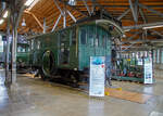 Die Drehstrom- Elektrolokomotive ex BTB De 2/2 Nr.1, ex BTB F 2/2 Nr. 1 (1902 – 1922), ex BTB E2E Nr. 1 (bis 1902), am 11.09.2022 in der Lokwelt Freilassing. Die Lok ist Eigentum des Deutschen Museums - Verkehrszentrum in München und eine Leihgabe die Lokwelt Freilassing

Dem Güterverkehr der Burgdorf-Thun-Bahn (BTB) dienten zwei Lokomotiven vom Typ F 2/2. Bis 1902 wurden sie als E2E bezeichnet, ab 1922 als De 2/2. Diese beiden ersten in der Schweiz, im Jahr 1899, gebauten elektrischen Lokomotiven (De 2/2 Nr.1 und  2) waren eine gemeinsame Konstruktion der Schweizerischen Lokomotiv- und Maschinenfabrik (SLM) in Winterthur für den mechanischen Teil und der Brown, Boveri & Cie. (BBC) für die elektrische Ausrüstung. 

Der noch nicht ausgereifte Einphasen-Wechselstrom-Betrieb konnte zur damaligen Zeit noch nicht eingesetzt werden. Deshalb beschaffte die Schweizer Burgdorf-Thun-Bahn (BTB) zunächst für den reinen Güterzugbetrieb zwei dieser mit Drehstrom (Dreiphasenwechselstrom) angetriebenen Lokomotiven. Das Drehstrom-System konnte nur in einem bestimmten Geschwindigkeitsbereich effektiv arbeiten, so dass ein mechanisches Schaltgetriebe für zwei maximale Geschwindigkeiten notwendig war, nämlich für 18 und 36 km/h.

Ab 1933 wurde der Drehstrombetrieb auf dieser Strecke eingestellt und die beiden Lokomotiven ausgemustert. Die beiden Lokomotiven sind als weltweit erste Drehstromlokomotiven für den Vollbahnbetrieb erhalten geblieben. Die Nr. 1 befindet in der Lokwelt Freilassing, die Nr. 2 befindet sich im Verkehrshaus der Schweiz in Luzern.

Die beiden Motoren wiesen eine Leistung von je 150 PS (110 kW) auf. Das nur im Stillstand umschaltbare Getriebe ermöglichte zwei Geschwindigkeiten, Die eine bis 18 km/h ließ auf der größten Steigung von 25 ‰ eine Anhängelast von 100 Tonnen zu, die andere bis 36 km/h noch die Hälfte. Wobei die zulässige Höchstgeschwindigkeit betrug 50 km/h, so wurde in den späteren Betriebsjahren in Gefällen stromlos gefahren, um diese zu erreichen. Dank der höheren Geschwindigkeit hätten die Lokomotiven nötigenfalls auch im Personenverkehr Verwendung finden können.

Die beiden 19-poligen Triebmotoren sind beidseits auf einer auf einem Hilfsgestell gelagerten gemeinsamen Welle montiert. Über ein Vorgelege wurde das Drehmoment mittels Kuppelstangen auf die beiden Achsen übertragen. Zum Anfahren war ein für beide Motoren gemeinsamer Widerstand vorhanden, der mit dem in jedem Führerstand vorhandenen Kontroller allmählich ausgeschaltet wurde. Beleuchtung, Heizung und Hilfsbetriebe wurden mit einer Spannung von 100 Volt betrieben. Die Lokomotiven weisen an beiden Enden offene Plattformen auf. Die vier Schleifbügel auf dem Dach legten sich selbsttätig beim Wechsel der Fahrtrichtung nach hinten um. Zum Abbügeln mussten die an den Bügeln angebrachten kurzen Zugseile vom Boden aus mit hölzernen Stangen heruntergezogen und in Arretierhaken eingehängt werden.

TECHNISCHE DATEN:
Baujahr: 1899, Ausmusterung1930
Spurweite: 1.435 mm (Normalspur)
Achsfolge: B
Länge über Puffer: 7.800  mm
Achsabstand: 3.140 mm
Treibraddurchmesser:  1.230 mm
Dienstgewicht: 29.600 kg
Höchstgeschwindigkeit: 18 km/h / 36 km/h (stromlos bergab 50 km/h)
Stundenleistung: 300 PS (220 kW)
Stundenzugkraft: 4.400 daN
Stromsystem: 750 V, 40 Hz ∆
Anzahl der Fahrmotoren: 2
Übersetzungsstufen: 2 (für 18 / 36 km/h)

Die Burgdorf-Thun-Bahn (BTB) war eine Eisenbahngesellschaft in der Schweiz. Ihre Strecke von Burgdorf über Konolfingen nach Thun wurde als erste elektrische Vollbahn der Schweiz im Jahr 1899 dem Betrieb übergeben. Heute ist sie Bestandteil der BLS AG
