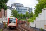 hamburger-hochbahn-ag/452694/zwei-gekuppelte-dt-3-n-dt Zwei gekuppelte DT 3 N (DT 3.2 E) der Hamburger Hochbahn, Linie U3, kurz vor dem Erreichen (am 16.06.2015) der Haltestelle Landungsbrücken.

Der DT3 ist die Bezeichnung von dreiteiligen U-Bahn-Triebfahrzeugen, die bei der Hamburger U-Bahn heute hauptsächlich auf der Linie U3 zum Einsatz kommen. Die Bezeichnung DT steht für Doppeltriebwagen, wobei die DT 3 im Gegensatz zu seinem Vorgänger – dem DT2 – durch einen zusätzlichen Mittelwagen ergänzt wurden, wodurch die Kapazität um 70 Plätze erhöht wurde. Dieser DT 3 ist eine Weiterentwicklung des Vorgängers DT2. Die Fahrzeuge wurden von 1968 bis 1971 von den Herstellern LHB (Linke-Hofmann-Busch), BBC und Kiepe produziert und sind seitdem im Einsatz.

Die dreiteiligen Triebzüge bestehen aus zwei End-Wagenkasten mit Führerstand und einem Mittelteil, sie ruhen auf je zwei Enddrehgestellen und zwei Jakobs-Drehgestellen.

Nach farblicher Auffrischung in den frühen 1980er Jahren und dem Einbau von Türsicherung, seitenselektiver Freigabe und Außenlautsprechern wurden die Fahrzeuge zwischen 1994 und 2000 grundlegend modernisiert. Der erste vollständig ertüchtigte, mit einer dem DT4 ähnlichen Stirnfront versehene DT3 war 1995 die Einheit 833. In die Ertüchtigung wurden insgesamt 68 Einheiten einbezogen, die restlichen Fahrzeuge wurden ausgemustert und bis 2003 verschrottet.

Bei den Erhaltungsmaßnahmen handelte es sich Erneuerung des inneren Profilskeletts der Wagenkästen und eine Sanierung der Langträger, da die tragenden Teile mittlerweile stark korrodiert waren. Der Fahrgastraum wurde in allen Waggons optisch in einem DT4-ähnlichen Stil aufgefrischt und durch Einbau von Fenstern in den Stirnwänden zwischen den Einzelwagen aufgehellt. Die Wagen können dank der Modernisierung weiter im Regelbetrieb verkehren. Ein neuerliches Redesign-Programm wurde im Jahr 2007 begonnen, aber nicht vollständig an allen Fahrzeugen durchgeführt. Dabei wurde der Innenraum erneut aufgefrischt: die Sitzpolster wurden mit blauen Bezügen bezogen und der Innenraum in einem sehr hellen Grauton lackiert, so dass fast die ursprüngliche Farbgebung wieder erreicht wird. Die Bezeichnung der ertüchtigten Fahrzeuge lautet DT3-E.

TECHNISCH DATEN:
Spurweite: 1.435 mm (Normalspur)
Achsformel: Bo'(Bo')(Bo')Bo'
Länge über Kupplung: 39.520 mm
Länge der Endwagen: 13.810 mm
Länge der Mittelwagen: 10.720 mm
Höhe: 3.350 mm
Breite: 2.480 mm
Drehzapfenabstand: 8.200 mm (Endwagen) / 6.680 mm (Mittelwagen)
Achsabstand im Drehgestell: 2.100 mm (Enddrehgestelle) / 2.550 mm (Jakobs-Drehgestelle)
Kleinster bef. Halbmesser: 60 m
Leergewicht: 47,1 t
Höchstgeschwindigkeit: 80 km/h
Stundenleistung: 8 × 80 kW = 640 kW
Beschleunigung: 1,2 m/s²
Raddurchmesser: 860 (neu) / 790 mm (abgenutzt)
Stromsystem: 750 V DC
Stromübertragung: seitliche, von unten bestrichene Stromschiene
Bremse: fremderregte Widerstandsbremse, Druckluft-Federspeicherbremse
Kupplungstyp: Scharfenberg
Sitzplätze: 92 
Stehplätze: 163
