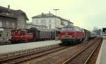 215 005-0 wartet um 1980 vor einem Eilzug nach Ulm im Bahnhof Friedrichshafen Stadt auf Fahrg�ste, der Dampf zwischen Lok und Packwagen zeigt, dass die Dampfheizung in Betrieb ist. Links rangiert eine 332 mit einigen Umbau-Vierachsern.