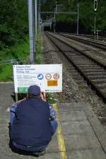 Auch in Zugpausen: immer auf der Suche nach Motiven. Mein Bruder fotografiert ein Hinweisschild zum Erlebnis-Pfad des BLS-Wanderweges entlang der Ltschberg Nordrampe am Bahnhof Blausee-Mitholz.(04.08.2007)
