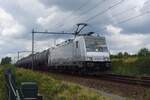 Akiem 186 365 zieht ein Kesselwagenzug durch das immer mehr zuwachsender Fotopunkt bei Tilburg-Reeshof am 21 Juli 2023.