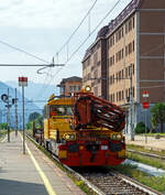 Das Italienische MerMec Gleisarbeitsfahrzeug IT-RFI 152 194-2 der RFI (Rete Ferroviaria Italiana) fährt am 08.09.2021 mit einem vierachsigen Flachwagen durch den Bahnhof Domodossola in Richtung