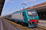 Lok E 464.557 wurde mit ihrem Zug auf einem Zwischengleis im Bahnhof von Verona in Wartestellung abgestellt.