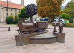   Auf dem Bahnhofsvorplatz von Diekirch ist diese Bronzeskulptur von einem Dampfzug mit darum herum spielenden Kindern aufgestellt.
