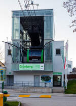 Die Talstation und eine Gondel der Luftseilbahn / Bergbahn Grnberg (Grnbergseilbahn) in Gmunden am Traunsee (Obersterreich) am 03. April 2025. 

Die Bergbahn Grnberg bringt einen mit einen der beiden modernen und groen Kabinen, die Platz fr je 60 Gste bieten, bequem und barrierefrei auf 1.004 Meter Seehhe. Bereits bei der Auffahrt mit der Bergbahn geniet man den malerischen Ausblick auf Gmunden, den Traunsee und die markante Gebirgskulisse des Hllengebirges und des Traunsteins, dem  Wchter des Salzkammergutes .

Die Bergbahn Grnberg ist eine Luftseilbahn, die auf den Gmundner Hausberg Grnberg fhrt. Die Anlage besteht seit 1957 und befrderte seither ber sechs Millionen Fahrgste. Die alte Zweiseilumlauf-Gondelbahn, die bis 2010 in Betrieb war, wurde 2013 demontiert und 2014 eine neue Pendelbahn erffnet.

Aufgrund der beengten Platzverhltnisse an der Talstation laufen die Mittelachsen der beiden Fahrbahnen (Trag- und Zugseil) nicht parallel, sondern haben in der Talstation eine Spurweite von nur 90 cm, um die Baubreite des Stationsgebudes zu verringern. Dafr betrgt die Spurweite an der ersten Sttze 10,25 m, um genug Abstand fr die Gondelbegegnung bei halber Strecke zu schaffen.

In der Talstation wurden automatische Schiebebahnsteige eingebaut, die die unterschiedlich groen Lcken – je nachdem, ob eine Gondel auf der linken oder rechten Seilstrecke einfhrt – zwischen Gondeltr und festem Bahnsteig berbrcken. Die Talstation selbst musste auf einer Bohrpfahlgrndung von 35 Pfhlen mit bis zu 17 m Tiefe errichtet werden, um die Krfte in standfesten Untergrund abzutragen.

Die vier Tragseile werden bei dieser Bahn nicht ber Spanngewichte gespannt, sondern sind an Berg- und Talstation fest an Seilpollern verankert. Das Zugseil ist eine endlos gespleite Schleife, an dem die Gondellaufwerke mit Seilklemmen befestigt sind. Dies ermglicht den Verzicht auf eine Fangbremsvorrichtung.

Die Bahn kann mit der niedrigeren Fahrgeschwindigkeit von 5,5 - 7 m/s zur Personaleinsparung ohne Wagenbegleiter betrieben werden. Es sind dann nur die beiden Stationen besetzt. Die maximale Geschwindigkeit bei der Sttzenberfahrt betrgt 8 m/s. Fahren Wagenbegleiter mit, kann die Anlage mit 10 m/s betrieben werden.

Die Kabinen bieten im begleiterlosem Normalbetrieb Platz fr 45 Personen. Bei starkem Fahrgastaufkommen knnen 60 Personen und der dann obligate Begleiter befrdert werden. Die Gondeln knnen flexibel durch ein Schnellwechselsystem mit 24 Sitzgelegenheiten ausgestattet werden. Fr Langguttransport wie die Bergfahrt von Hngegleitern sind an den Stirnseiten der Gondeln spezielle Ladegutffnungen vorhanden.

TECHNISCHE DATEN:
Betreiber: Bergbahnen Dachstein Salzkammergut
Bahnsystem: Zweiseil-Pendelbahn, ohne Fangbremse (Hersteller: Ludwig Steurer Maschinen und Seilbahnbau GmbH & Co KG, Doren/Vorarlberg)
Kabinen: 2 Grokabinen (Hersteller Carvatech in Oberweis, Laakirchen – heute Teil der Doppelmayr Gruppe, ex Swoboda Seilbahnbau GmbH)
Fassungsvermgen je Kabine: 60 + 1 Personen (Normalbetrieb 45 Pers, 24 Sitzpltze)
Antrieb: Elektromotor mit 350 kW Leistung in der Bergstation
Anzahl Sttzen: 2 Stck
Fahrstrecke: 1.969 m
Hhe Talstation: 435,75 m..M.
Hhe Bergstation: 986,64 m..M.
Hhenunterschied: 550,89 m
Mittlere Neigung: 28,26 %
Grte Neigung: 57,06 %
Lngstes Spannfeld: 1.440 m (zwischen Talstation und erster Sttze)
Seilspur: 0,90 bis 10,25 m
Tragseile:  46 mm, vollverschlossene Stahlseile (Fa. Teufelberger Wels)
Zugseil:  28 mm Durchmesser als endlose Seilschliefe (Fa. Teufelberger Wels)
Fahrgeschwindigkeit: max. 10m/s begleitet, 7,0 m/s ohne Wagenbegleiter, 5,5 m/s in Schwachlastzeiten
Fahrtdauer: ca. 7 Minuten
Befrderungsleistung je Richtung: 420 Pers./h
