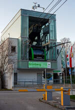 Die Talstation und eine Gondel der Luftseilbahn / Bergbahn Grnberg (Grnbergseilbahn) in Gmunden am Traunsee (Obersterreich) am 03. April 2025. 

Die Bergbahn Grnberg bringt einen mit einen der beiden modernen und groen Kabinen, die Platz fr je 60 Gste bieten, bequem und barrierefrei auf 1.004 Meter Seehhe. Bereits bei der Auffahrt mit der Bergbahn geniet man den malerischen Ausblick auf Gmunden, den Traunsee und die markante Gebirgskulisse des Hllengebirges und des Traunsteins, dem  Wchter des Salzkammergutes .

Die Bergbahn Grnberg ist eine Luftseilbahn, die auf den Gmundner Hausberg Grnberg fhrt. Die Anlage besteht seit 1957 und befrderte seither ber sechs Millionen Fahrgste. Die alte Zweiseilumlauf-Gondelbahn, die bis 2010 in Betrieb war, wurde 2013 demontiert und 2014 eine neue Pendelbahn erffnet.

Aufgrund der beengten Platzverhltnisse an der Talstation laufen die Mittelachsen der beiden Fahrbahnen (Trag- und Zugseil) nicht parallel, sondern haben in der Talstation eine Spurweite von nur 90 cm, um die Baubreite des Stationsgebudes zu verringern. Dafr betrgt die Spurweite an der ersten Sttze 10,25 m, um genug Abstand fr die Gondelbegegnung bei halber Strecke zu schaffen.

In der Talstation wurden automatische Schiebebahnsteige eingebaut, die die unterschiedlich groen Lcken – je nachdem, ob eine Gondel auf der linken oder rechten Seilstrecke einfhrt – zwischen Gondeltr und festem Bahnsteig berbrcken. Die Talstation selbst musste auf einer Bohrpfahlgrndung von 35 Pfhlen mit bis zu 17 m Tiefe errichtet werden, um die Krfte in standfesten Untergrund abzutragen.

Die vier Tragseile werden bei dieser Bahn nicht ber Spanngewichte gespannt, sondern sind an Berg- und Talstation fest an Seilpollern verankert. Das Zugseil ist eine endlos gespleite Schleife, an dem die Gondellaufwerke mit Seilklemmen befestigt sind. Dies ermglicht den Verzicht auf eine Fangbremsvorrichtung.

Die Bahn kann mit der niedrigeren Fahrgeschwindigkeit von 5,5 - 7 m/s zur Personaleinsparung ohne Wagenbegleiter betrieben werden. Es sind dann nur die beiden Stationen besetzt. Die maximale Geschwindigkeit bei der Sttzenberfahrt betrgt 8 m/s. Fahren Wagenbegleiter mit, kann die Anlage mit 10 m/s betrieben werden.

Die Kabinen bieten im begleiterlosem Normalbetrieb Platz fr 45 Personen. Bei starkem Fahrgastaufkommen knnen 60 Personen und der dann obligate Begleiter befrdert werden. Die Gondeln knnen flexibel durch ein Schnellwechselsystem mit 24 Sitzgelegenheiten ausgestattet werden. Fr Langguttransport wie die Bergfahrt von Hngegleitern sind an den Stirnseiten der Gondeln spezielle Ladegutffnungen vorhanden.

TECHNISCHE DATEN:
Betreiber: Bergbahnen Dachstein Salzkammergut
Bahnsystem: Zweiseil-Pendelbahn, ohne Fangbremse (Hersteller: Ludwig Steurer Maschinen und Seilbahnbau GmbH & Co KG, Doren/Vorarlberg)
Kabinen: 2 Grokabinen (Hersteller Carvatech in Oberweis, Laakirchen – heute Teil der Doppelmayr Gruppe, ex Swoboda Seilbahnbau GmbH)
Fassungsvermgen je Kabine: 60 + 1 Personen (Normalbetrieb 45 Pers, 24 Sitzpltze)
Antrieb: Elektromotor mit 350 kW Leistung in der Bergstation
Anzahl Sttzen: 2 Stck
Fahrstrecke: 1.969 m
Hhe Talstation: 435,75 m..M.
Hhe Bergstation: 986,64 m..M.
Hhenunterschied: 550,89 m
Mittlere Neigung: 28,26 %
Grte Neigung: 57,06 %
Lngstes Spannfeld: 1.440 m (zwischen Talstation und erster Sttze)
Seilspur: 0,90 bis 10,25 m
Tragseile:  46 mm, vollverschlossene Stahlseile (Fa. Teufelberger Wels)
Zugseil:  28 mm Durchmesser als endlose Seilschliefe (Fa. Teufelberger Wels)
Fahrgeschwindigkeit: max. 10m/s begleitet, 7,0 m/s ohne Wagenbegleiter, 5,5 m/s in Schwachlastzeiten
Fahrtdauer: ca. 7 Minuten
Befrderungsleistung je Richtung: 420 Pers./h
